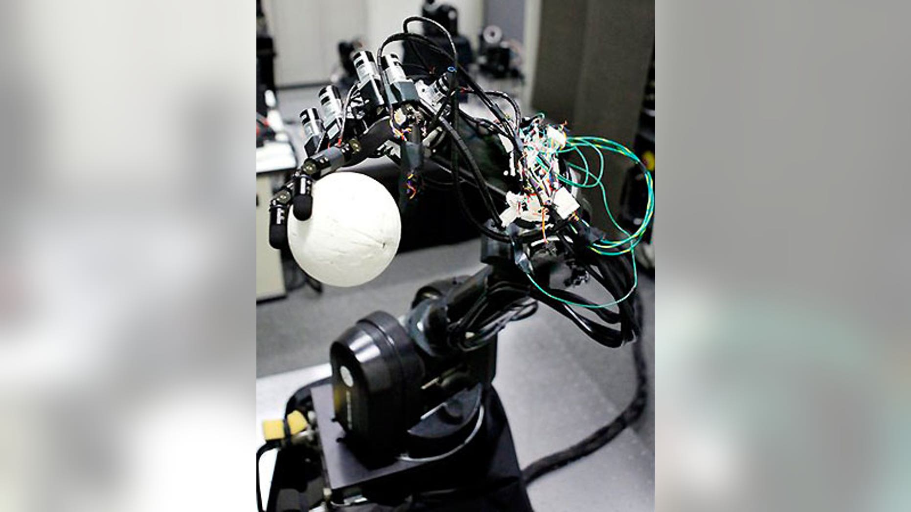 July 24: A pitching robot grips a ball made of polystyrene during its demonstration at the University of Tokyo.
