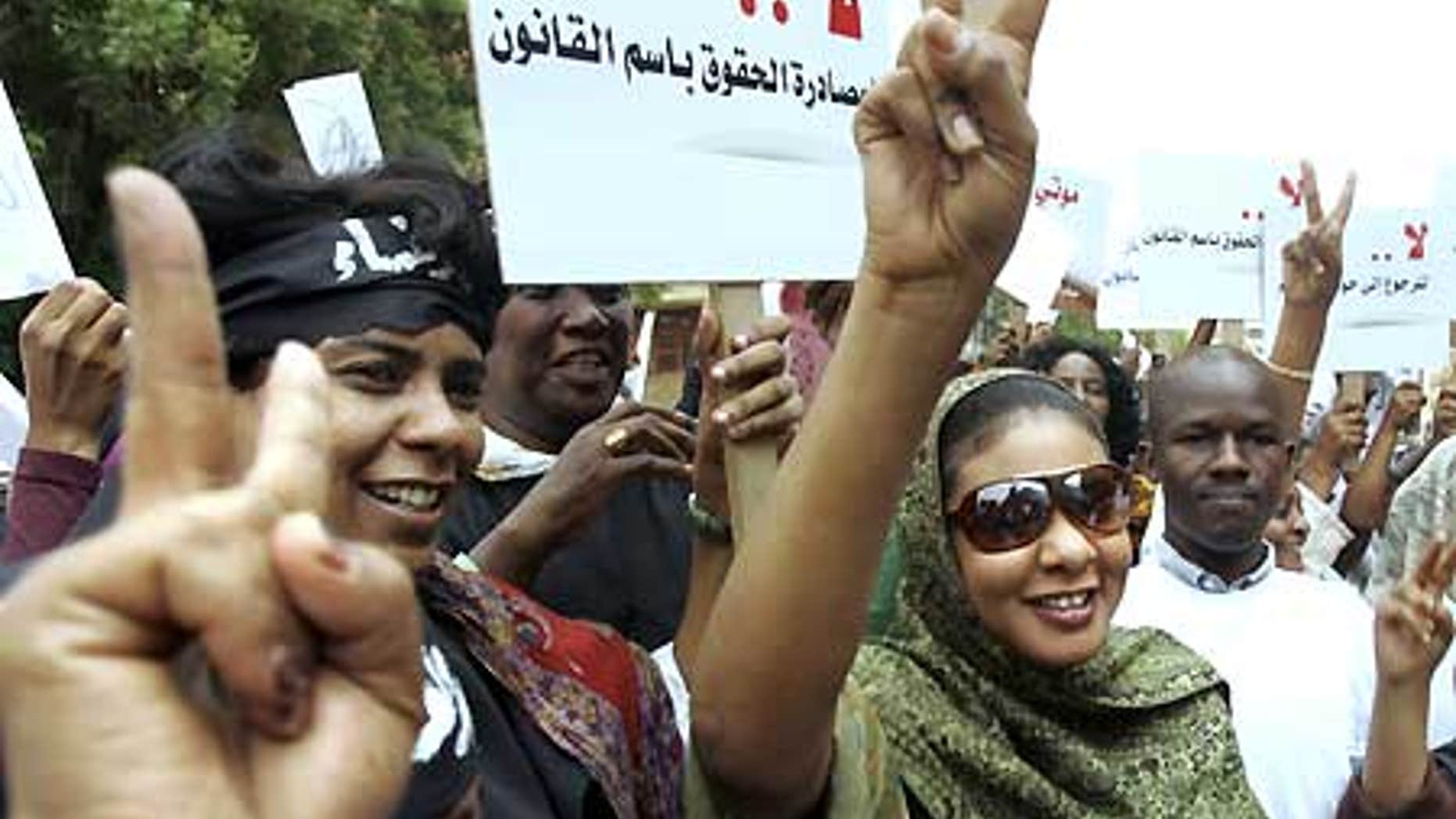Aug. 4: Sudanese journalist Lubna Hussein, right, who faces 40 lashes on the charge of 'indecent dressing,' flashes a victory sign to her supporters.