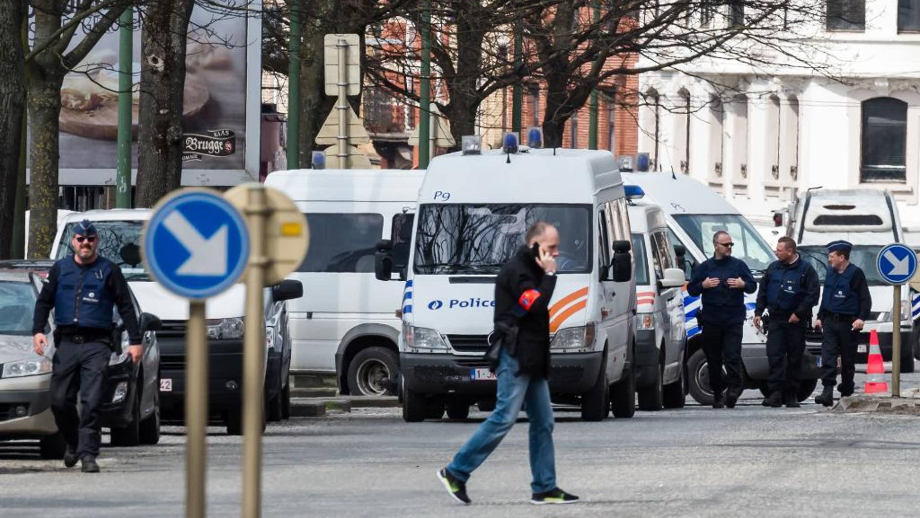 Police secure an area during a house search in the Etterbeek neighborhood in Brussels on Saturday April 9, 2016. The arrest Friday of six men suspected of links to the Brussels bombings, including the last known fugitive in last year's Paris attacks, raised new questions about the extent of the Islamic State cell believed to have carried out the intertwined attacks that left 162 people dead in two countries. (AP Photo/Geert Vanden Wijngaert)
