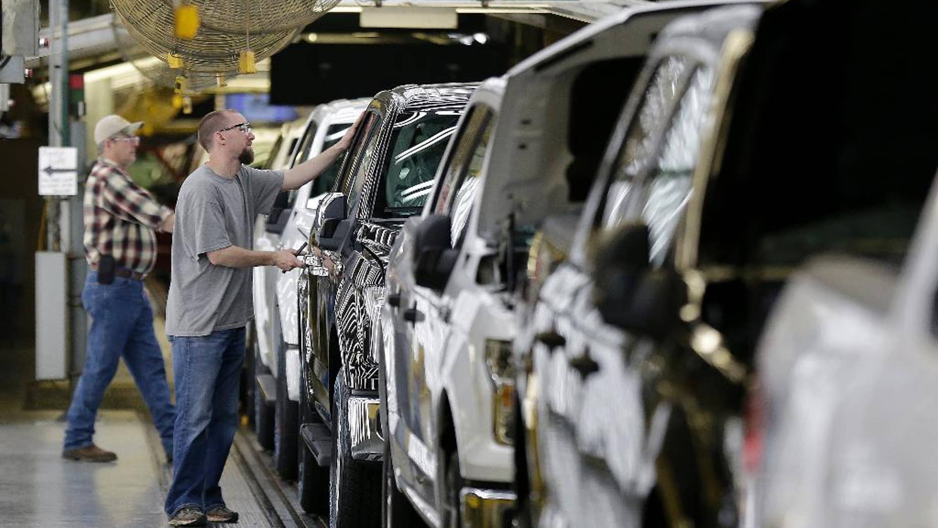 FILE - In this March 13, 2015, file photo, a worker inspects a new 2015 aluminum-alloy body Ford F-150 truck at the company's Kansas City Assembly Plant, in Claycomo, Mo. The Commerce Department releases its October report on orders for durable goods, items expected to last at least three years, on Wednesday, Nov. 25, 2015. (AP Photo/Charlie Riedel, File)