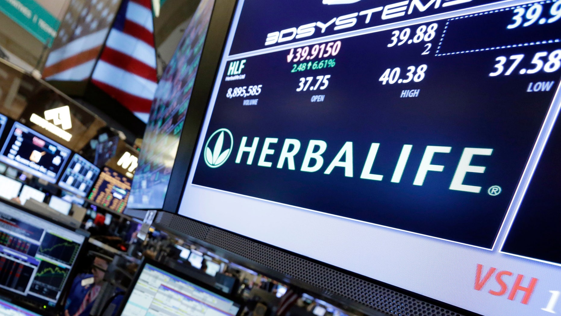 FILE - In this Feb. 28, 2013, file photo, a pair of specialists confer at the post that handles Herbalife on the floor of the New York Stock Exchange. A judge dismissed a lawsuit Tuesday, March 17, 2015, by Herbalife shareholders who claimed that the business structure and marketing practices of the weight loss and nutritional supplements company violated the law and that they lost money in what amounts to a pyramid scheme. (AP Photo/Richard Drew, File)