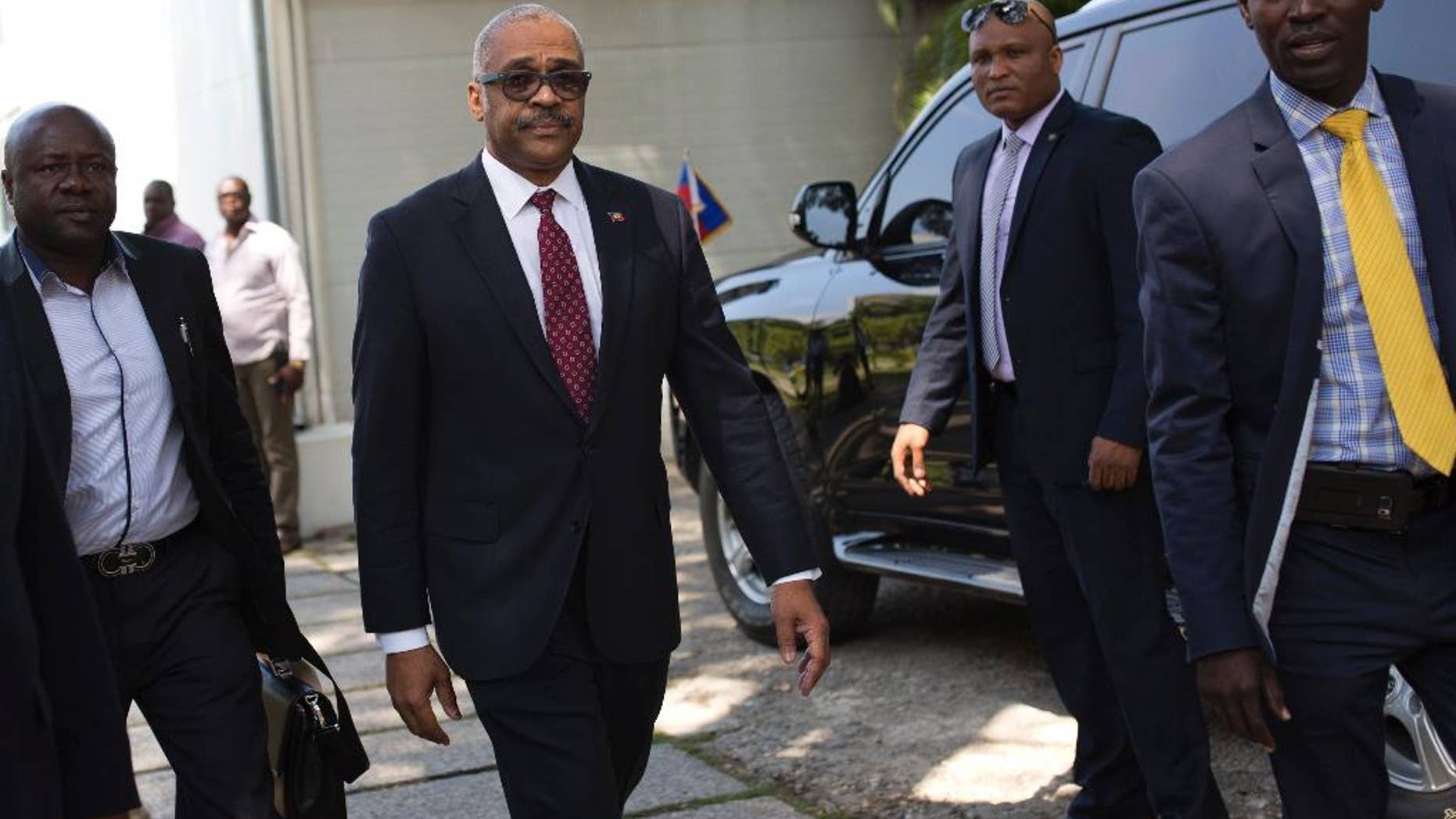 FILE - In this Feb. 24, 2017, file photo, Haiti's newly nominated Prime Minister Dr. Jack Guy Lafontant, center, arrives at the national palace for his nomination ceremony in Port-au-Prince, Haiti. Lafontant, a gastroenterologist and head of the Rotary Club in the commercial district of Petionville has been ratified as Haiti's Prime Minister on Tuesday, March 21. (AP Photo/Dieu Nalio Chery, File)
