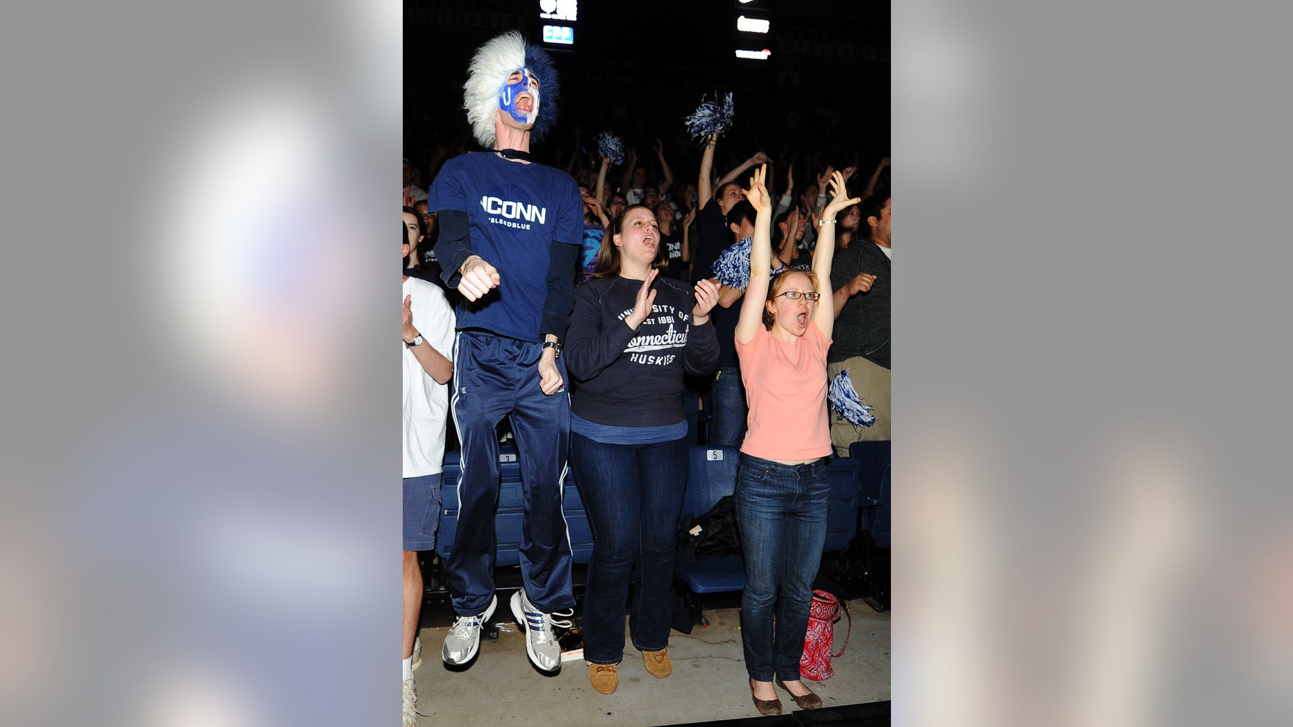 From left, John Dearborn, Laura Hatchman and Grace Vasington cheer as they watch a broadcast of the Connecticut women's team playing Louisville in the NCAA Final Four college basketball tournament championship game in New Orleans, Tuesday, April 9, 2013, at Gampel Pavilion in Storrs, Conn. (AP Photo/Journal Inquirer, Jim Michaud) MANDATORY CREDIT