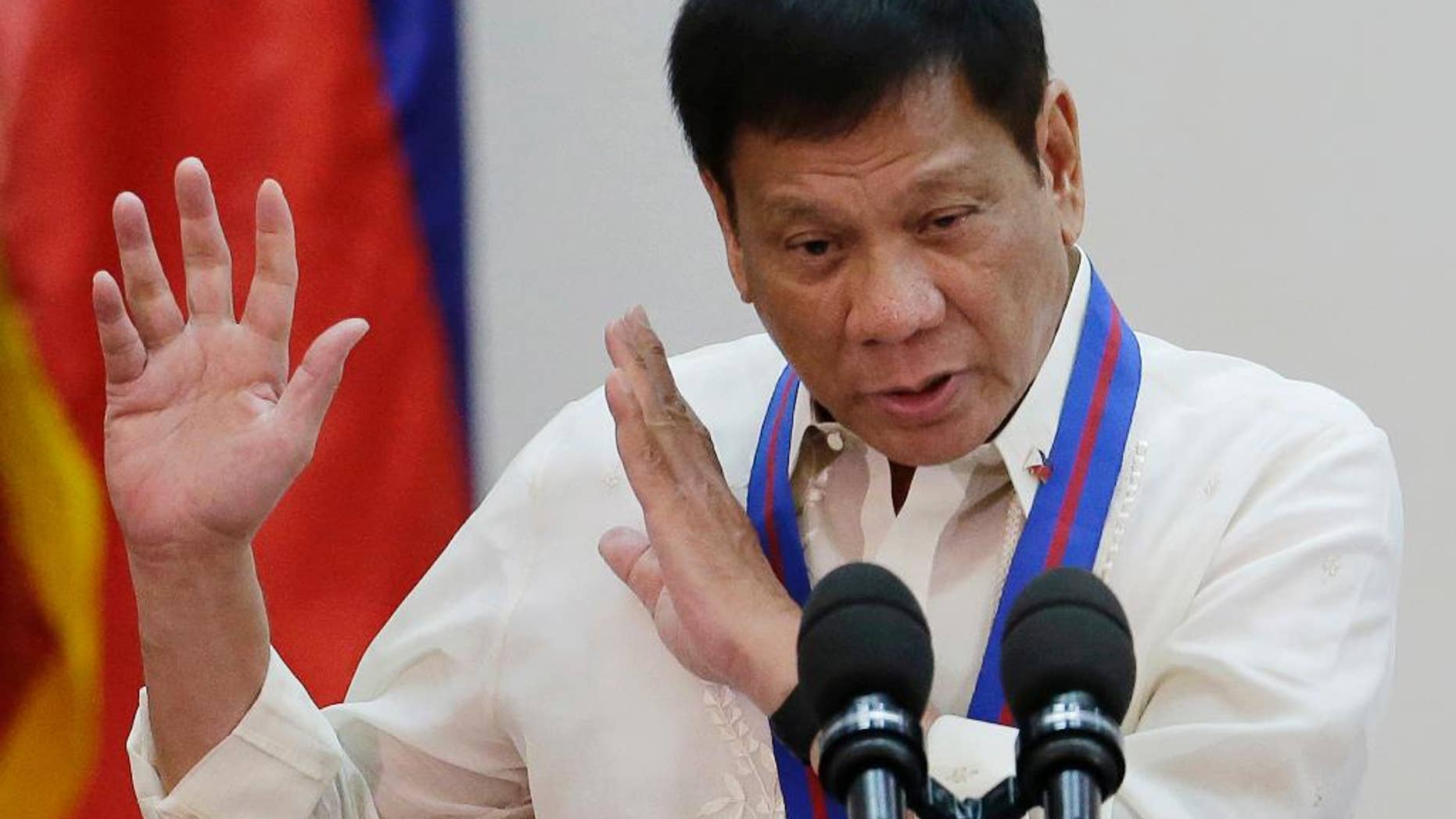 FILE - In this July 1, 2016, file photo, Philippine President Rodrigo Duterte gestures during the "Assumption of Command" of new Police Chief, Director General Ronald Dela Rosa at Camp Crame, Philippine National Police headquarters, in suburban Quezon city, Philippines. Duterte publicly linked more than 150 judges, mayors, lawmakers, police and military personnel to illegal drugs Sunday, Aug. 7, 2016, ordering them to surrender for investigation as he ratcheted up his bloody war against what he calls a "pandemic." Duterte promptly relieved members of the military and police he named from their current posts and ordered government security personnel to be withdrawn from politicians he identified in a nationally televised speech. (AP Photo/Aaron Favila, File)