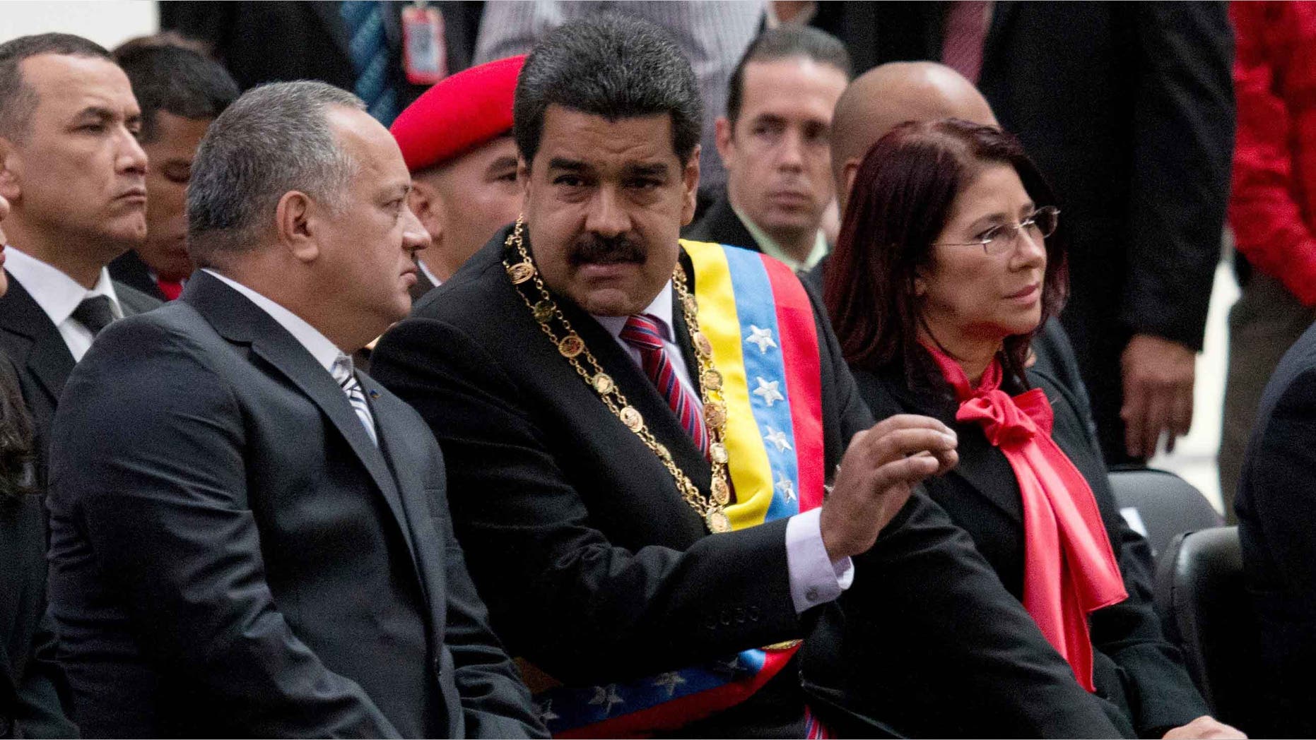 El presidente venezolano Nicolás Maduro, al centro, habla con Diosdado Cabello, presidente de la Asamblea Nacional, izquierda, durante una ceremonia para conmemorar el 185to aniversario de la muerte del héroe independentista Simón Bolivar en Caracas, Venezuela, el jueves 17 de diciembre de 2015. La mujer a la derecha es la primera dama Cilia Flores. (Foto AP/Fernando Llano)