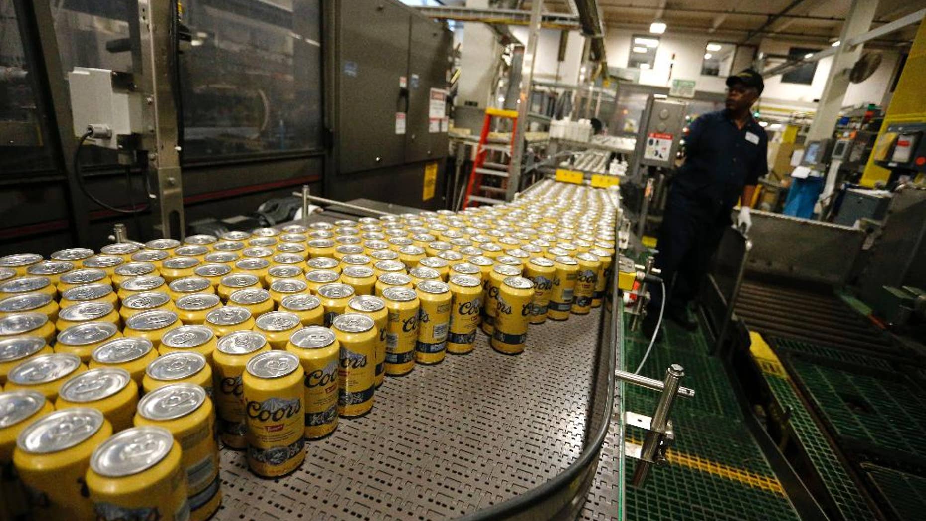 In this March 11, 2015 photo, newly-filled and sealed cans of Coors Banquet beer move along on a conveyor belt at the MillerCoors Brewery, in Golden, Colo. The Labor Department releases the Producer Price Index for March on Tuesday, April 14, 2015. (AP Photo/Brennan Linsley)