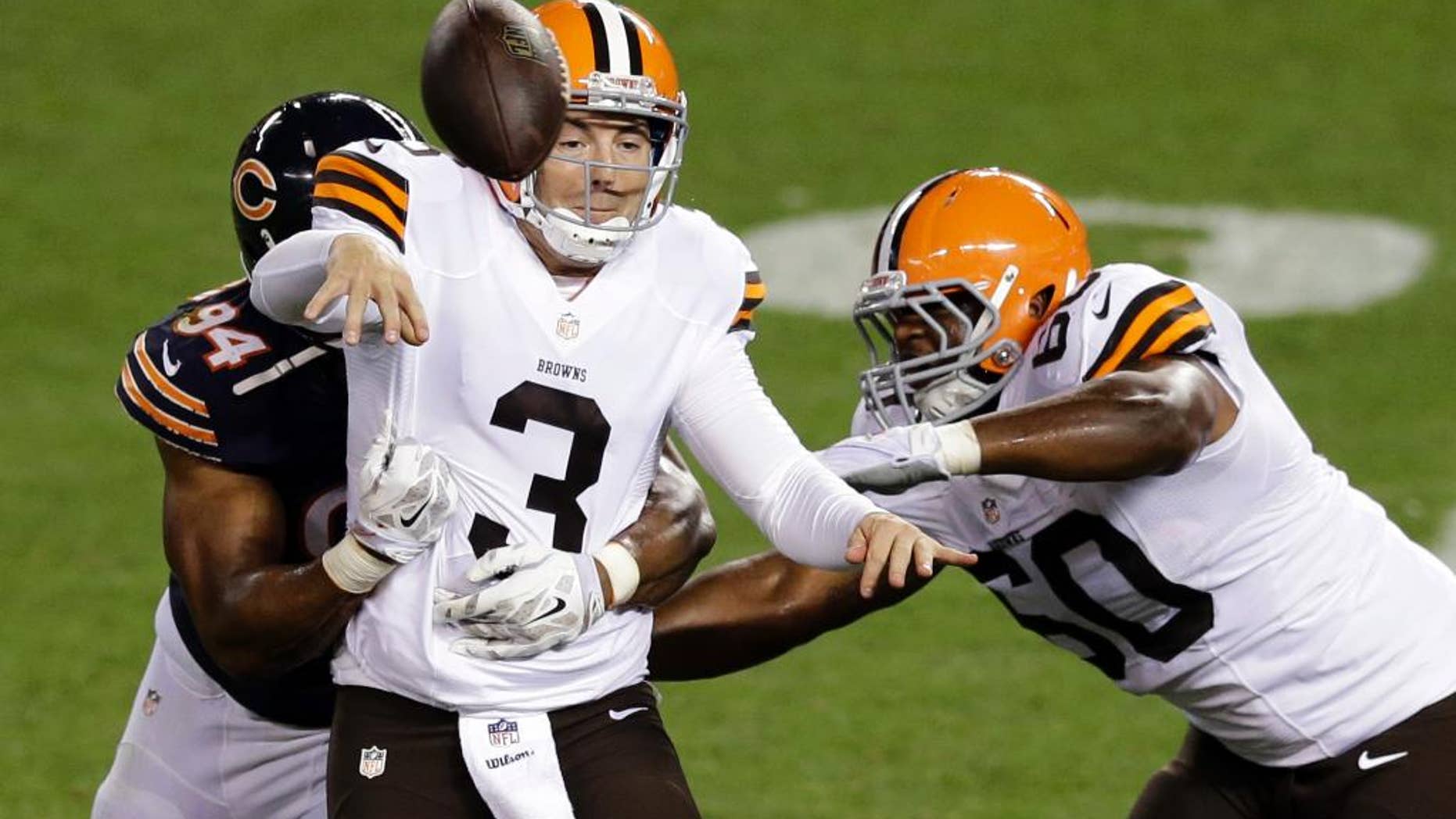 Cleveland Browns quarterback Rex Grossman (3) throws an incomplete pass after being hit by Chicago Bears defensive end Cornelius Washington (94) in the third quarter of a preseason NFL football game Thursday, Aug. 28, 2014, in Cleveland. (AP Photo/Tony Dejak)