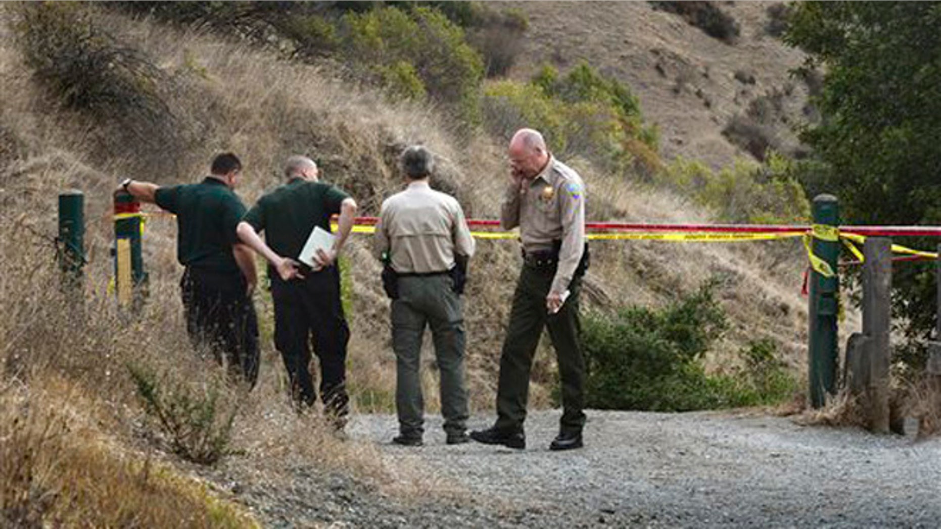 In this Tuesday, Oct. 6, 2015 photo, Marin County Sheriff's members investigate a homicide near the top of White's Hill on Old Railroad Grade near Fairfax, Calif.