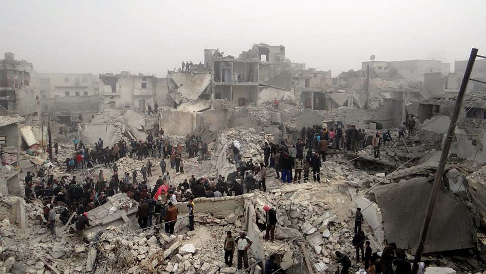 This citizen journalism image provided by Aleppo Media Center AMC, which has been authenticated based on its contents and other AP reporting, shows people searching through the debris of destroyed buildings in the aftermath of a strike by Syrian government forces, in the neighborhood of Jabal Bedro, Aleppo, Syria, Tuesday Feb. 19, 2013. The U.N. Commission of Inquiry on Syria released a 131-page report Monday, Feb. 18, 2013, detailing deepening radicalization by both sides and says fighters on both sides in Syria's civil war have committed atrocities and should be brought to justice. (AP Photo/Aleppo Media Center AMC)