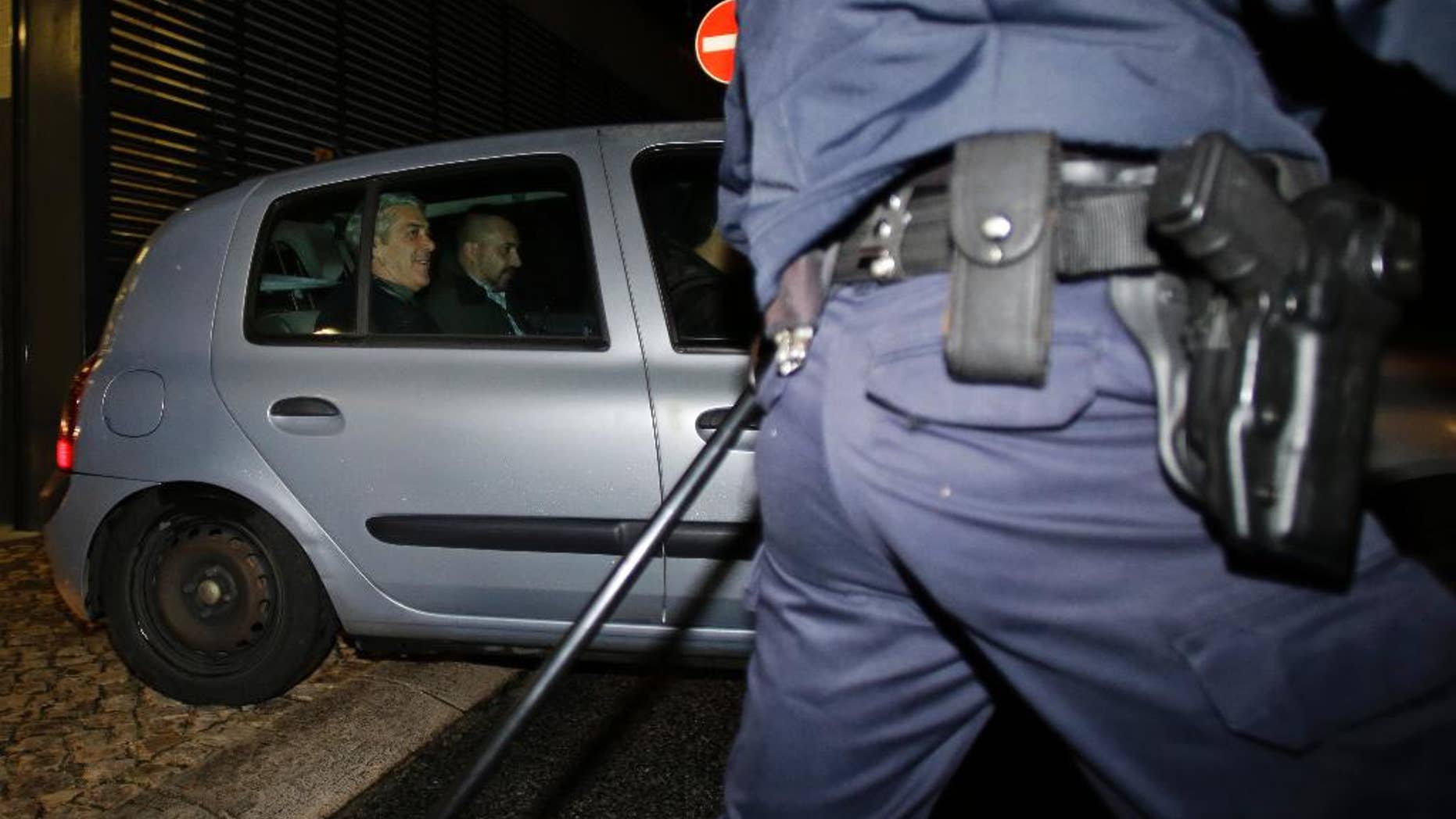 Portugal's former Prime Minister Jose Socrates, at left in the back seat of the car, leaves a court in a Portuguese police car after being questioned, in Lisbon, Sunday, Nov. 23, 2014. Socrates, who was Portugal's center-left Socialist Prime Minister from 2005 to 2011, was due in a Lisbon court Sunday for a closed-door interrogation, deciding whether he should answer charges of alleged corruption, money-laundering and tax fraud. (AP Photo/Francisco Seco)
