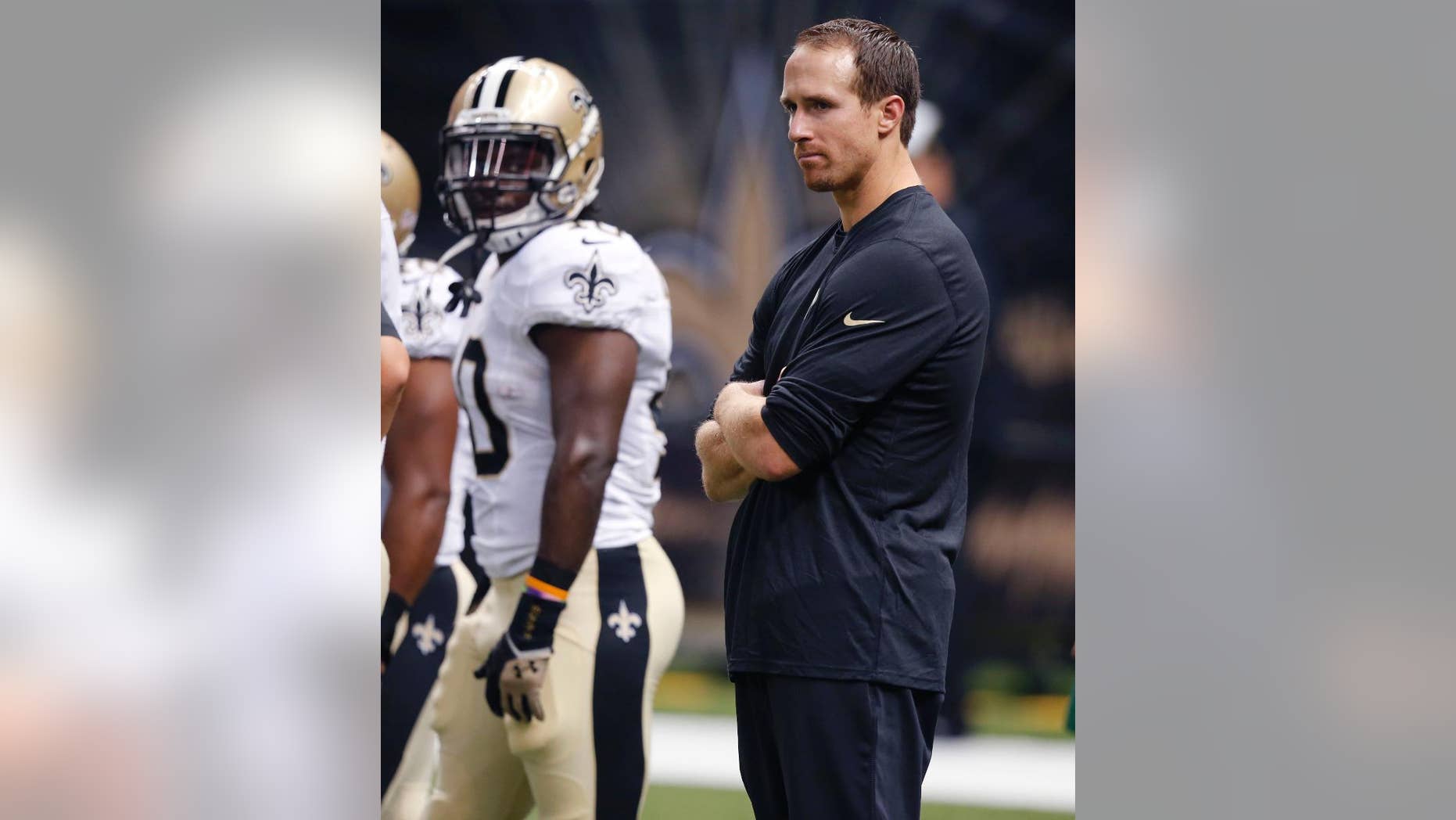 New Orleans Saints quarterback Drew Brees watches from the sideline in street clothes before an NFL football game against the Tennessee Titans in New Orleans, Friday, Aug. 15, 2014. (AP Photo/Bill Haber)