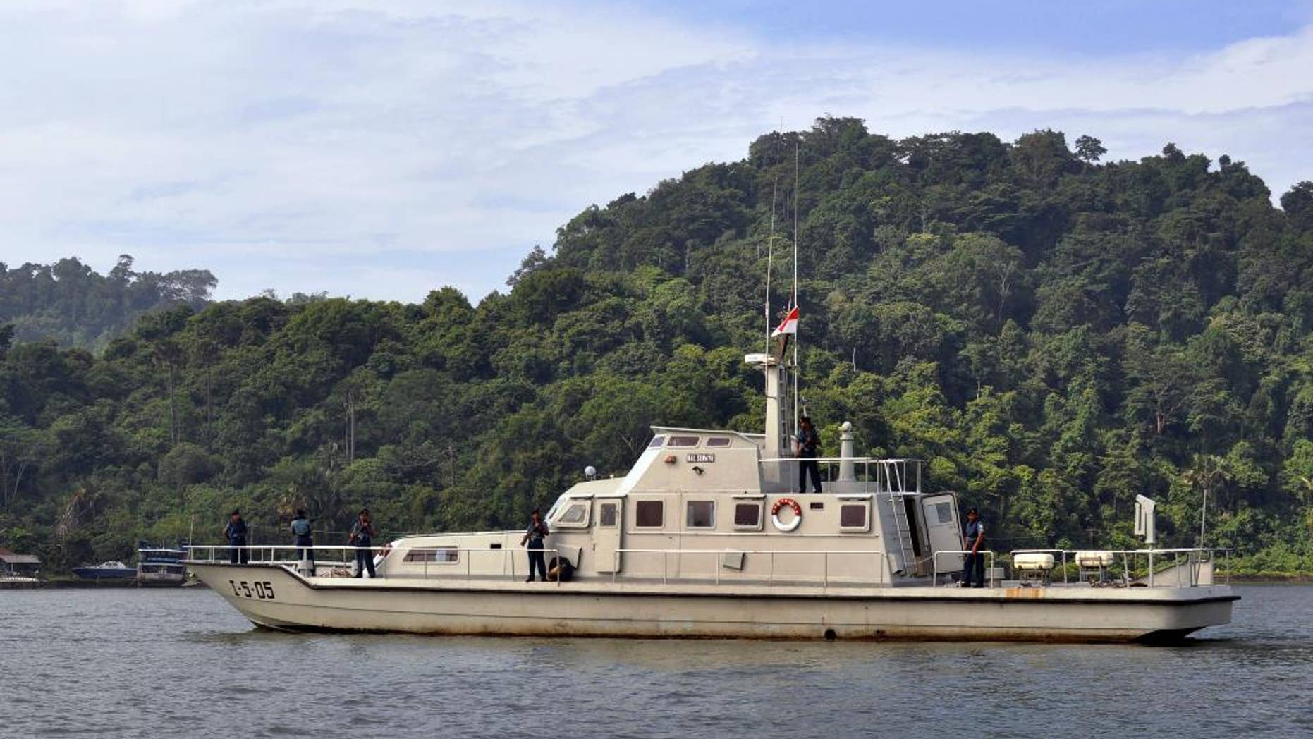 An Indonesian Navy boat carrying armed crew members patrol the waters near the prison island of Nusakambangan, background, where the planned executions of seven convicted foreign drug smugglers will be performed, in Cilacap, Central Java, Indonesia, Tuesday, Feb. 24, 2015. Indonesia is preparing the executions of the drug convicts from Australia, Brazil, France, Ghana, Nigeria and the Philippines. (AP Photo/Wagino)