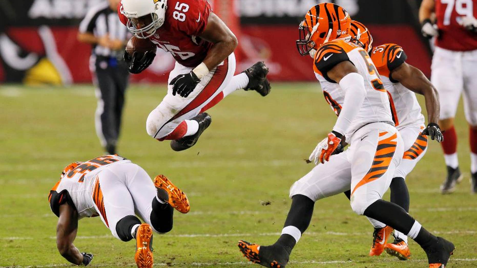 Arizona Cardinals tight end Darren Fells (85) is hit by Cincinnati Bengals strong safety Shawn Williams, bottom, during the second half of an NFL preseason football game, Sunday, Aug. 24, 2014, in Glendale, Ariz. (AP Photo/Ross D. Franklin)