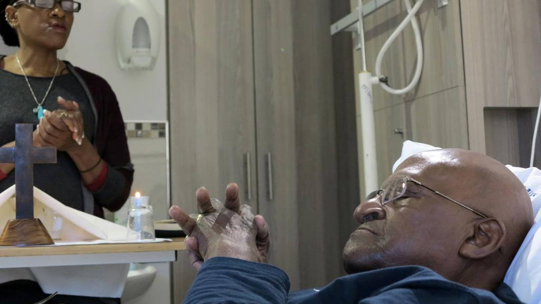 In this photo provided by Oryx Media shows retired Anglican Archbishop Desmond Tutu, praying in his hospital bed in Cape Town, South Africa Tuesday Aug. 4, 2015. Tutu left the hospital after being treated for an infection there since last month, his foundation said. (Benny Gool/Oryx Media via AP) CREDIT MANDATORY
