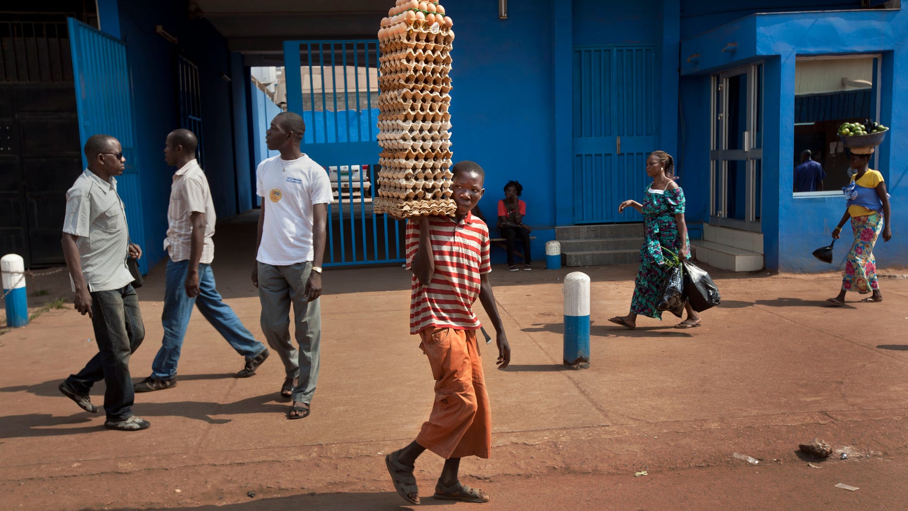 A young street vendor selling eggs walks past a demonstration held by several hundred merchants calling for peace as negotiators prepare for talks with rebels from the north, in downtown Bangui, Central African Republic Saturday, Jan. 5, 2013. The U.N. Security Council urged rebels in the Central African Republic on Friday to halt their military offensive, withdraw from cities they have seized, and take part in negotiations to find a political solution to the impoverished country's longstanding problems. (AP Photo/Ben Curtis)