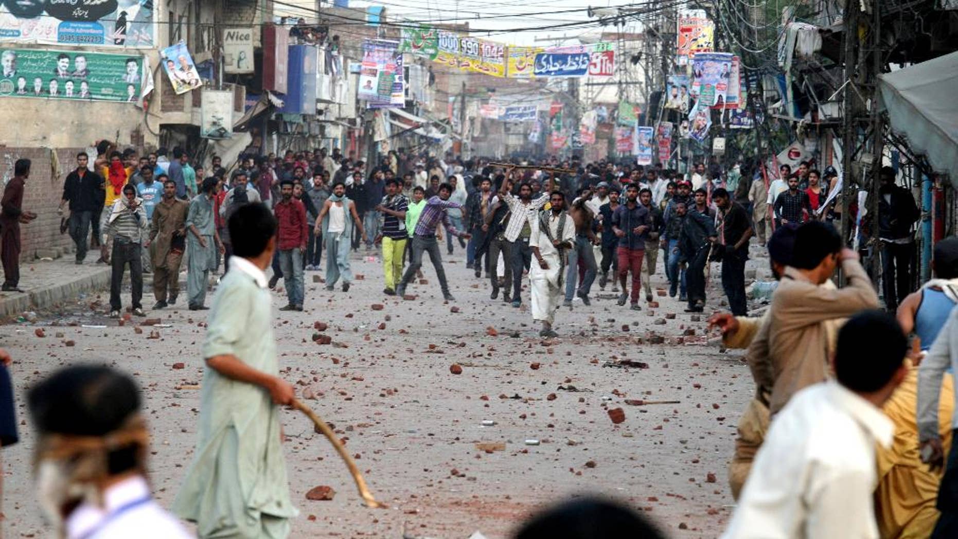 Pakistani protesters throw rocks during clashes with police to condemn Sunday's suicide bombings that struck two churches, in Lahore, Pakistan, Monday, March 16, 2015. Pakistani police fired tear gas on Monday after Christian protesters clashed with police in the eastern city of Lahore, a day after Taliban bombers killed more than a dozen people in suicide attacks on two churches in the city. (AP Photo/K.M. Chaudary)
