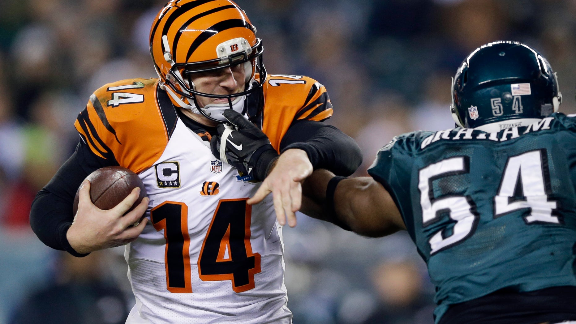 Cincinnati Bengals' Andy Dalton, left, tries to break free from Philadelphia Eagles' Brandon Graham in the second half of an NFL football game, Thursday, Dec. 13, 2012, in Philadelphia. (AP Photo/Matt Rourke)