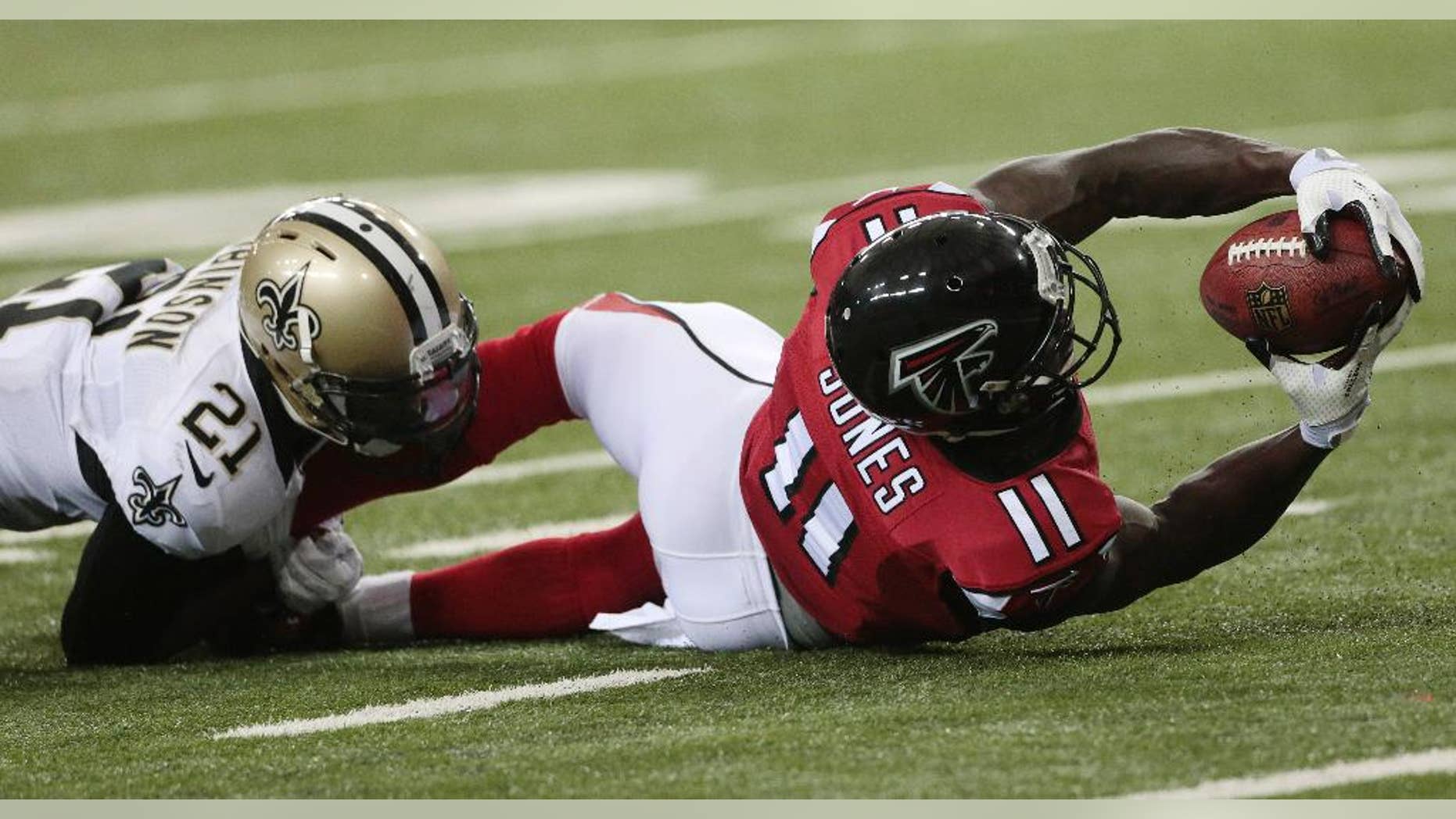 Atlanta Falcons wide receiver Julio Jones (11) stretches after making a catch against New Orleans Saints cornerback Patrick Robinson (21) during the second half of an NFL football game, Sunday, Sept. 7, 2014, in Atlanta. (AP Photo/John Bazemore)