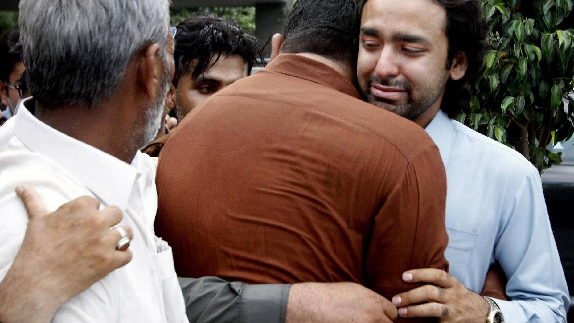In this May 2013 file photo, people comfort Musa Gilani, right, the brother of Ali Haider Gilani who was kidnapped in Multan, Pakistan.