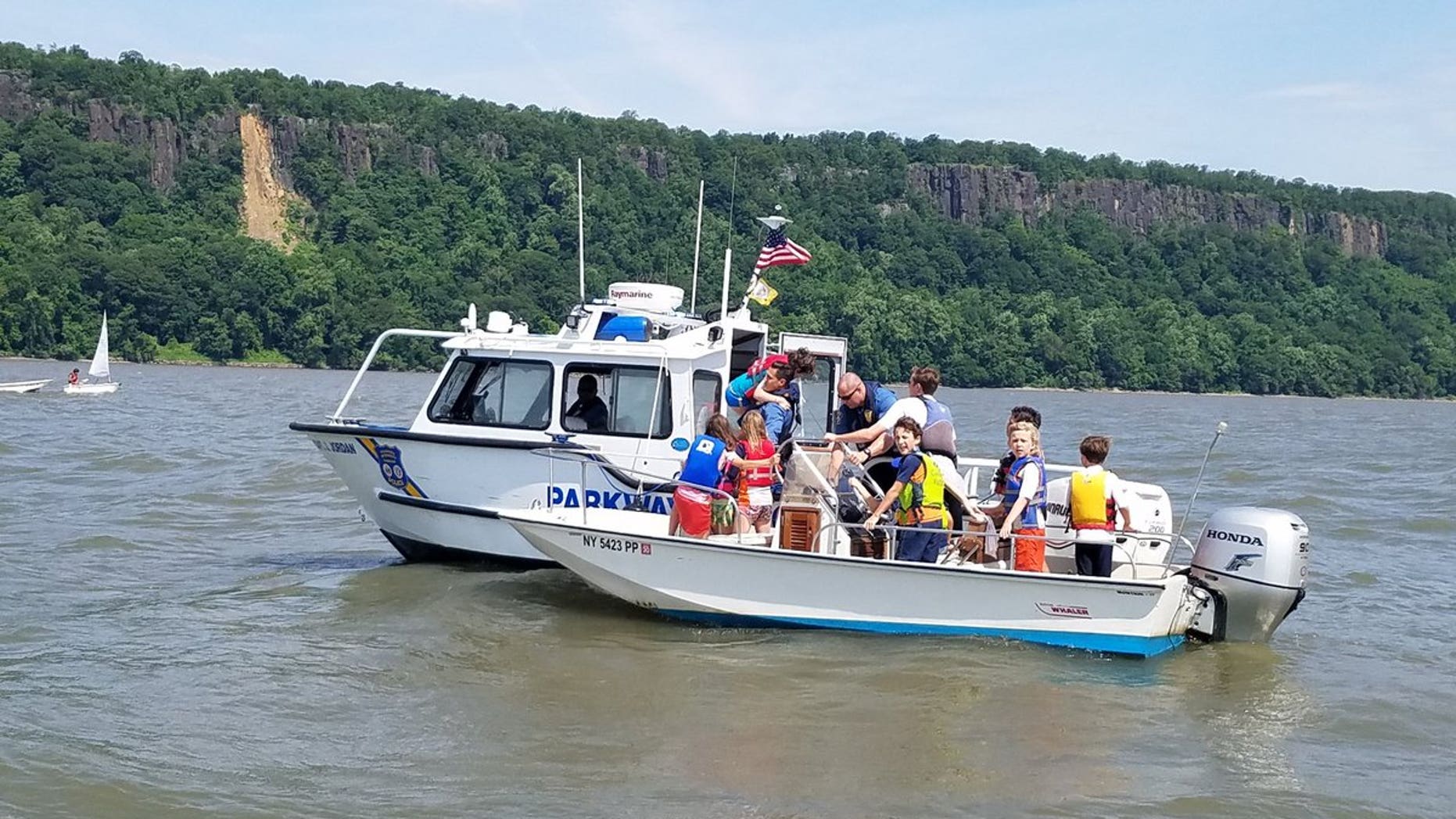 A small sailboat capsized in the Hudson River off New York City, sending children on board into the water.