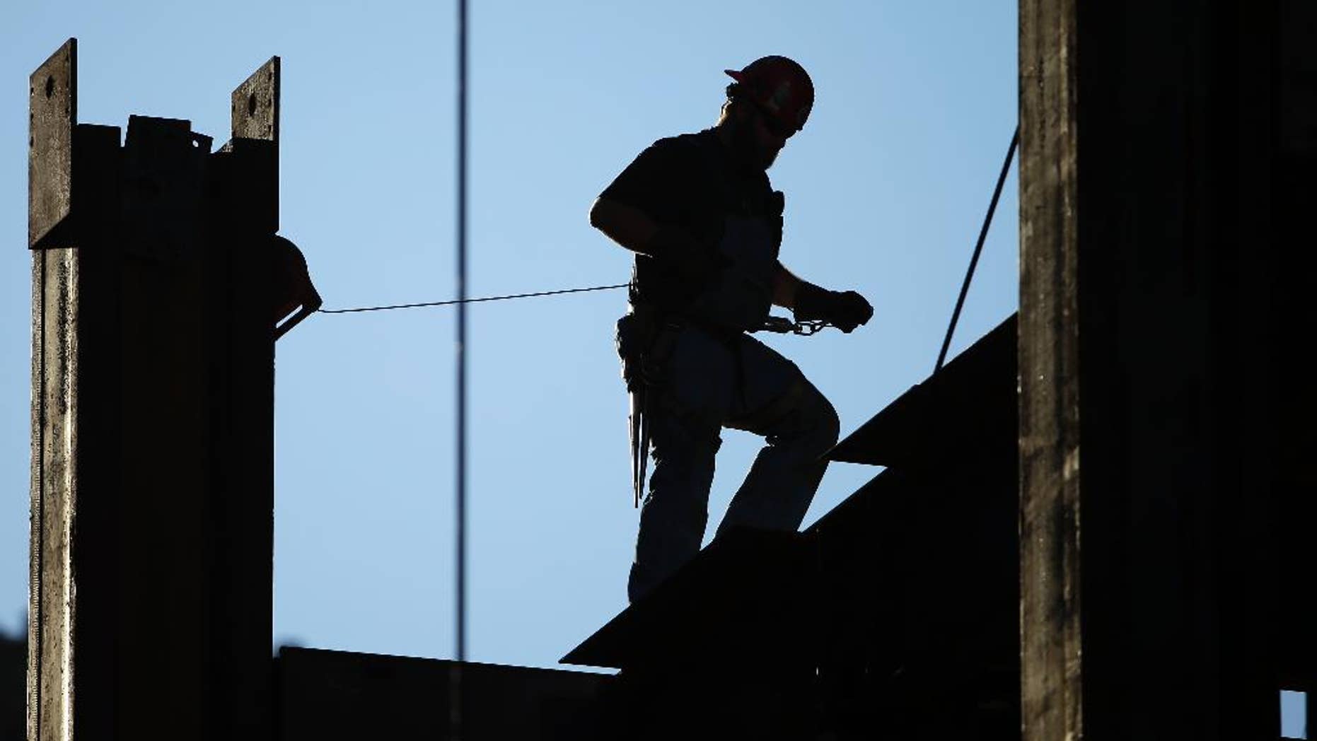 FILE - In this Sept. 15, 2015, file photo, an iron worker works on the new Comcast Innovation and Technology Center under construction, in Philadelphia. The Commerce Department reports on U.S. construction spending in November, on Monday, Jan. 4, 2016. (AP Photo/Matt Rourke, File)