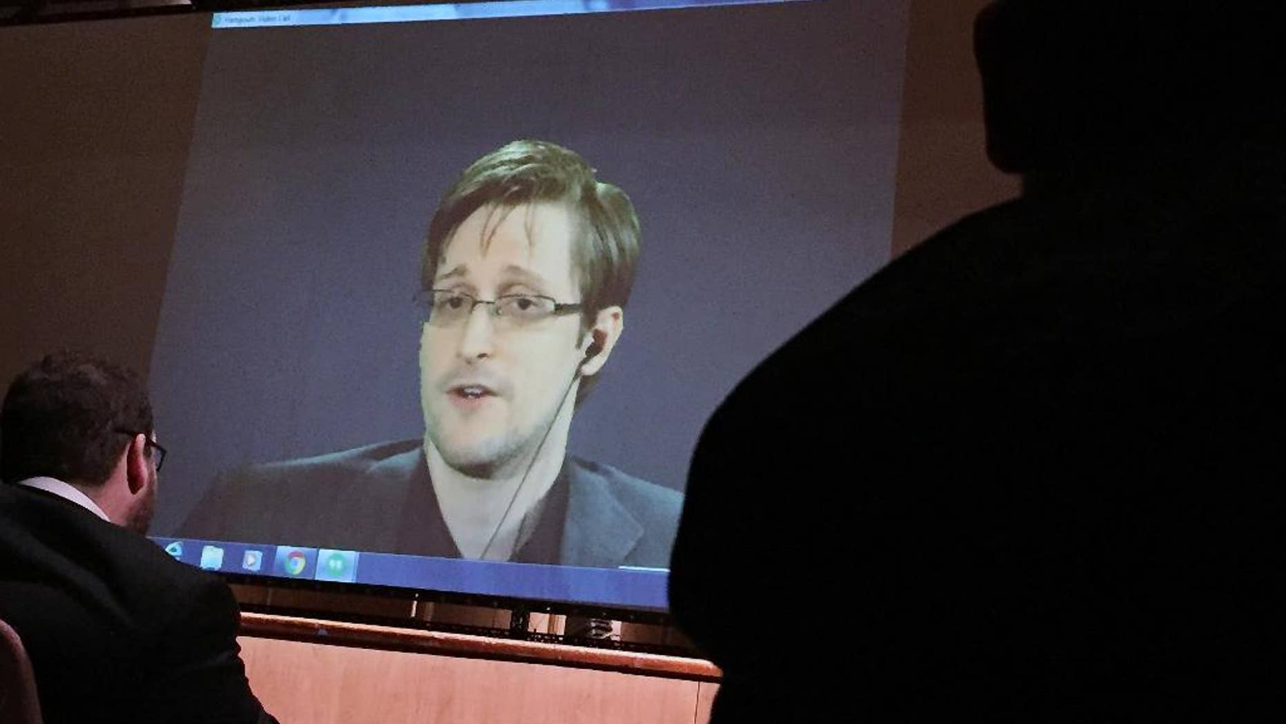 FILE- In this Feb. 17, 2016, file photo, former National Security Agency contractor Edward Snowden, center, speaks via video conference to people in the Johns Hopkins University auditorium in Baltimore. The Intercept, an online news site whose founding editors were the first to publish documents leaked by Snowden, released on Monday, May 16, the first batch of nine years' worth of the newsletters, which offer a behind-the-scenes glimpse into the NSA’s work. (AP Photo/Juliet Linderman, File)