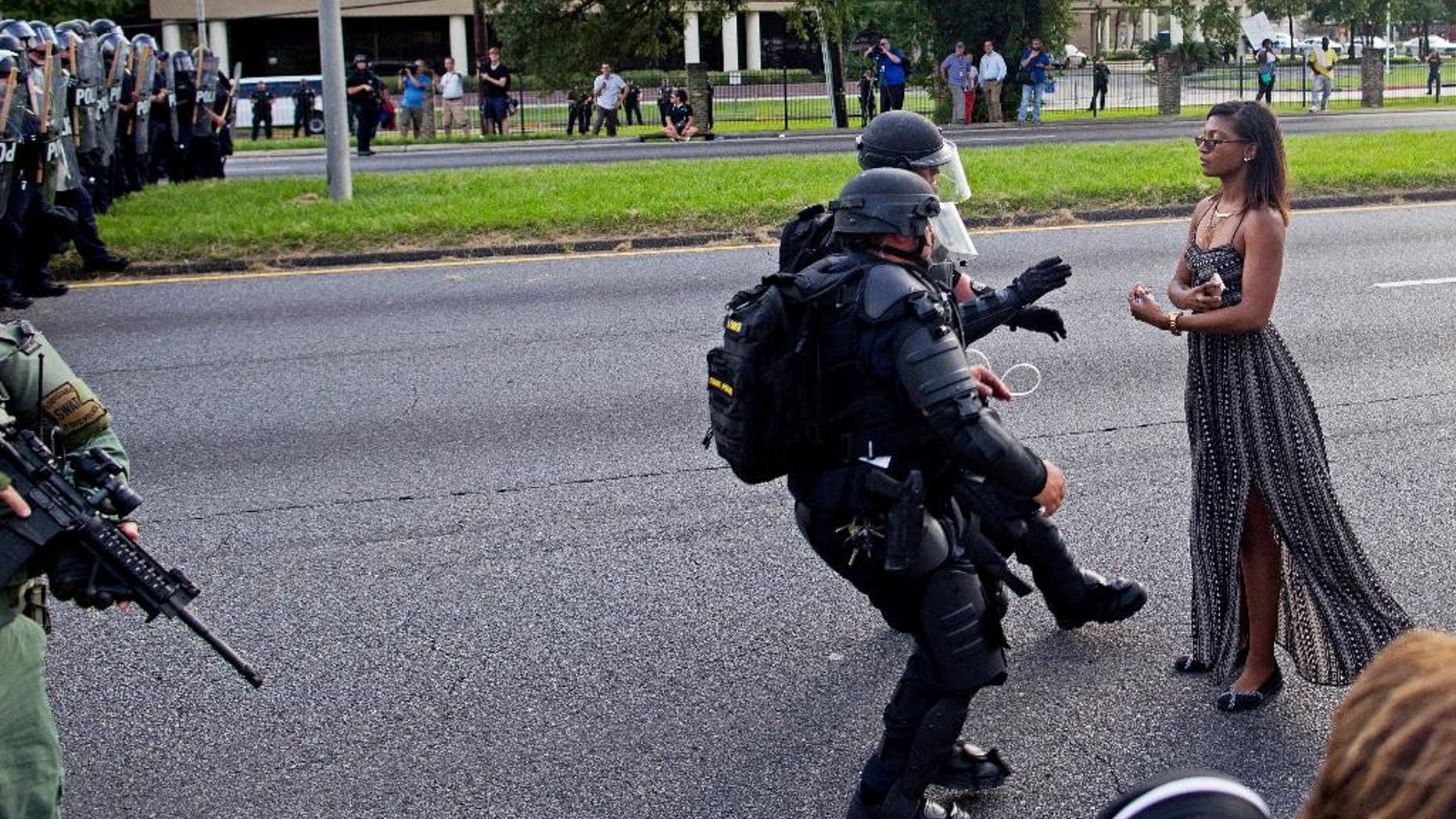 FILE In this Saturday, July 9, 2016 file photo, A protester is grabbed by police officers in riot gear after she refused to leave the motor way in front of the the Baton Rouge Police Department Headquarters in Baton Rouge, La. Police made nearly 200 arrests in Louisiana's capital city during weekend protests around the country in which people angry over police killings of young black men sought to block some major interstates. (AP Photo/Max Becherer)