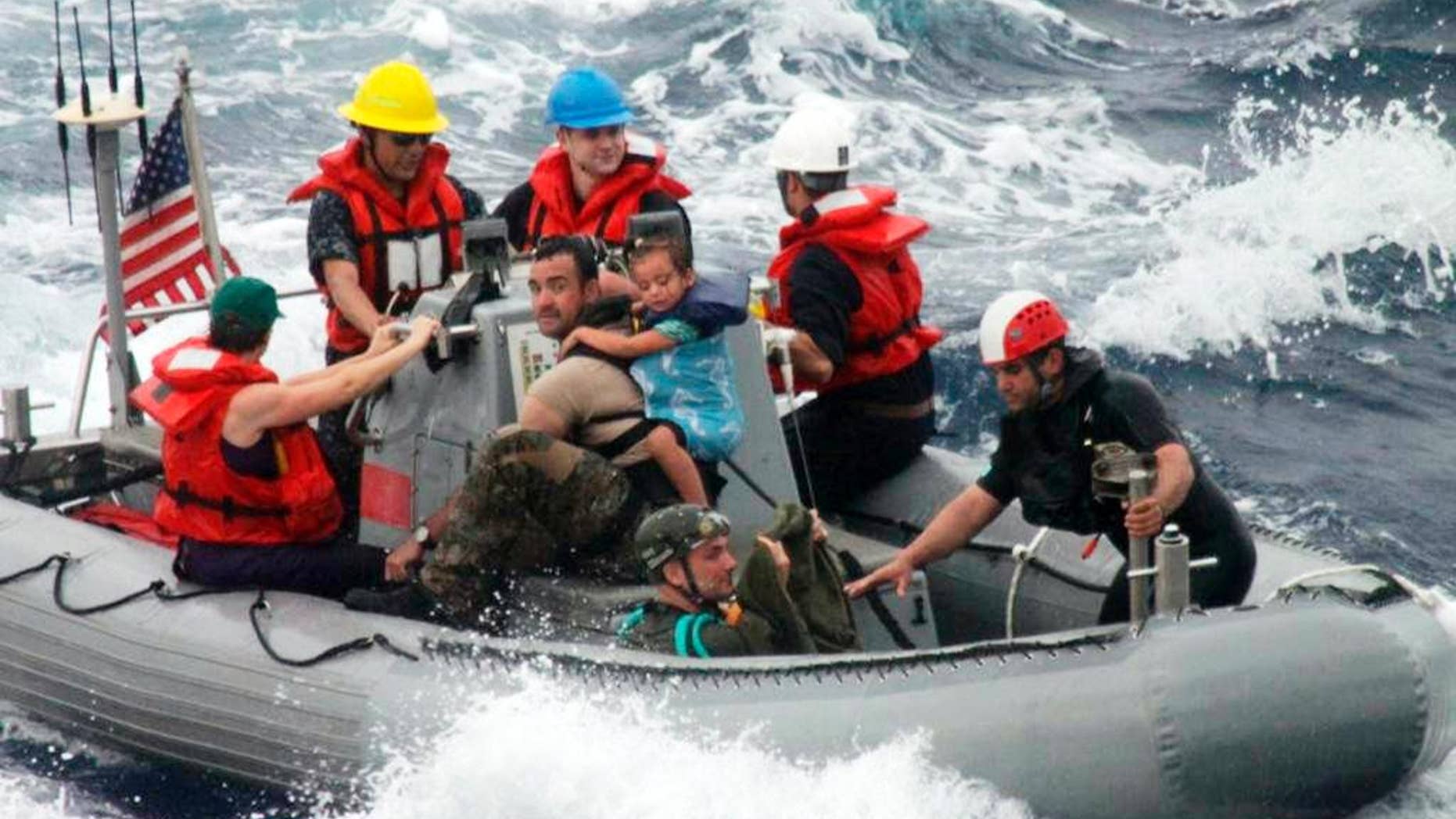 FILE - In this April 6, 2014, file photo, provided by the U.S. Coast Guard, sailors from the frigate USS Vandegrift assist in the rescue of the Kaufman family with a sick infant on the ship's small boat, as part of a joint U.S. Navy, Coast Guard and California Air National Guard rescue effort. None of the three federal agencies that helped rescue the ill 1-year-old, Lyra Kaufman, and her family from their broken down sailboat about 900 miles off Mexico's Pacific coast plan to seek reimbursement for the cost of the operation. Officials from the Navy, Coast Guard and California Air National Guard said Tuesday, April 8, 2014, they don't charge for search-and-rescue missions. "We don't want people in trouble at sea to hesitate to call for help for fear they'll be charged for assistance," said Lt. Anna Dixon of the 11th Coast Guard District, which oversaw the operation but did not send vessels or aircraft to the stranded sailboat. She said that helping at sea is a time-honored tradition and a requirement of international maritime convention. The Navy warship that picked up the family on Sunday is expected to reach San Diego on Wednesday. (AP Photo/U.S. Coast Guard, File)