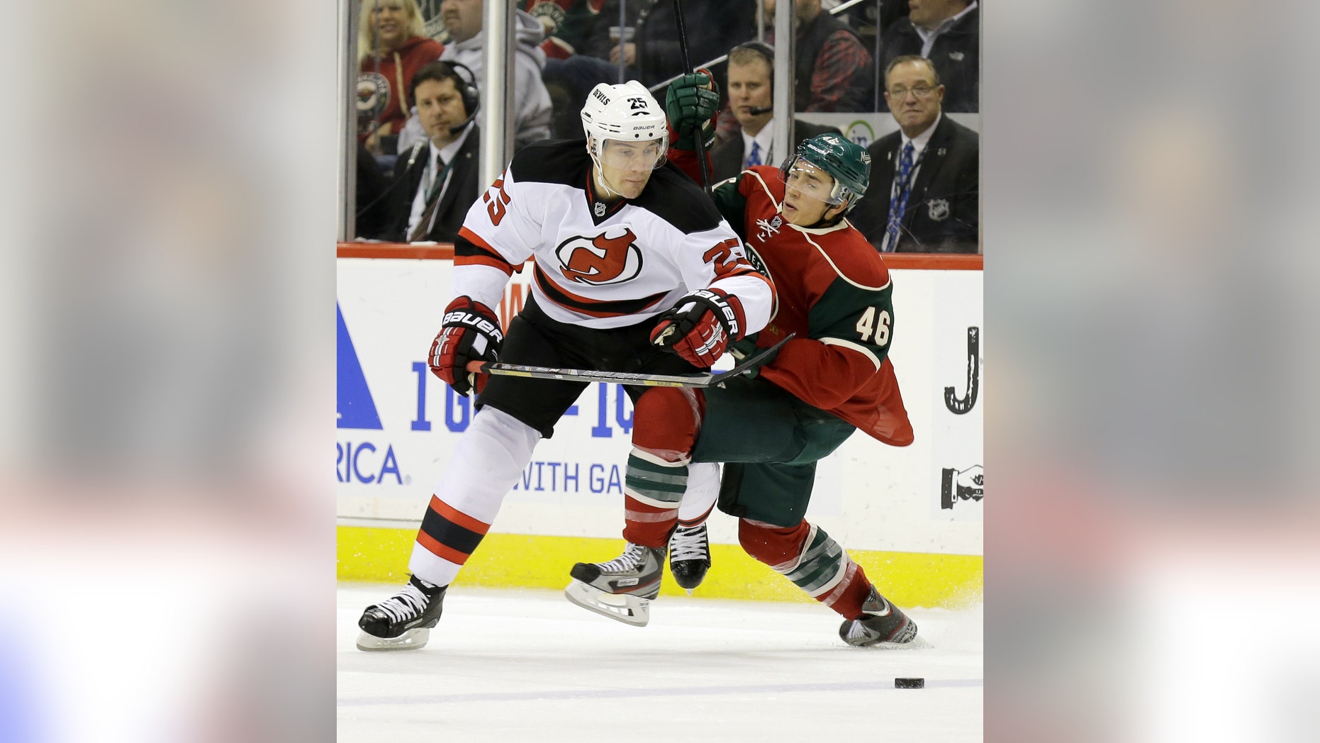 New Jersey Devils center Rostislav Olesz (25), of Czech Republic, and Minnesota Wild defenseman Jared Spurgeon get tangled as they battle for the puck during the second period of an NHL hockey game in St. Paul, Minn., Sunday, Nov. 3, 2013. (AP Photo/Ann Heisenfelt)