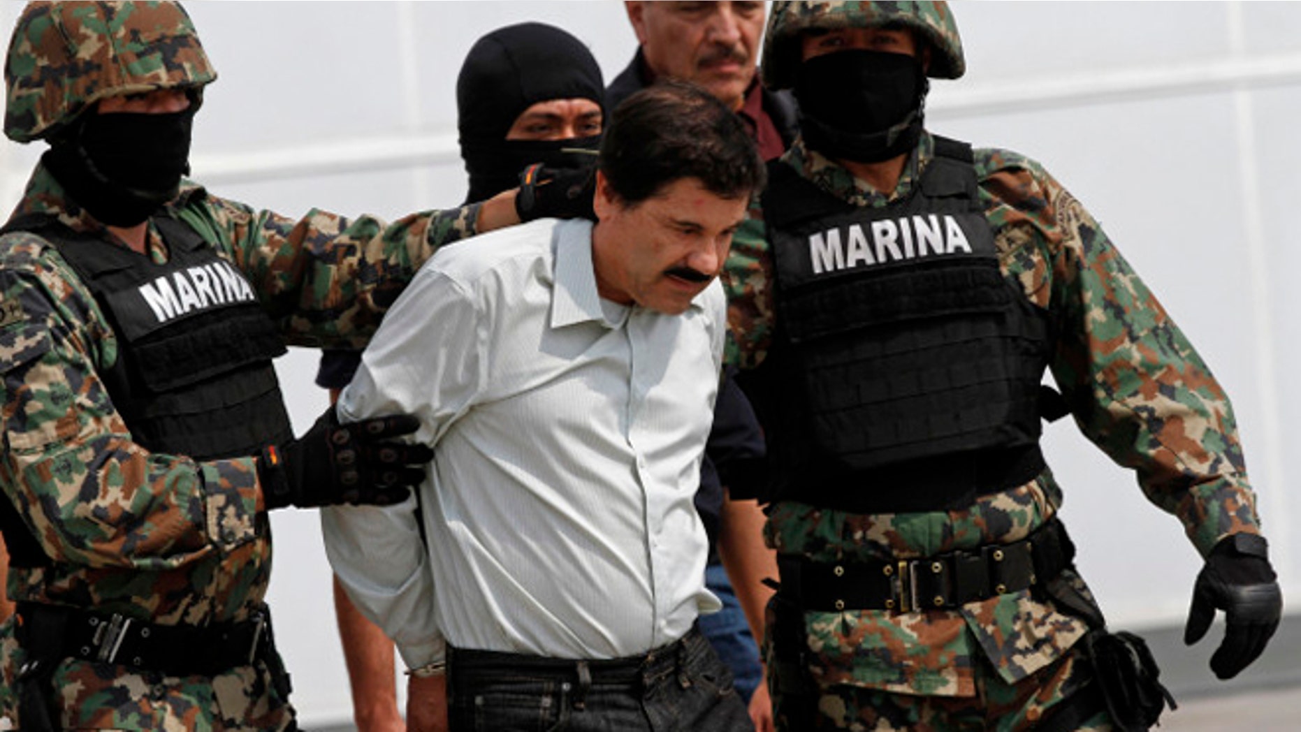 Joaquin "El Chapo" Guzman is escorted to a helicopter in handcuffs by Mexican navy marines at a navy hanger in Mexico City, Saturday, Feb. 22, 2014. A senior U.S. law enforcement official said Saturday, that Guzman, the head of MexicoÃs Sinaloa Cartel, was captured alive overnight in the beach resort town of Mazatlan. Guzman faces multiple federal drug trafficking indictments in the U.S. and is on the Drug Enforcement AdministrationÃs most-wanted list. (AP Photo/Marco Ugarte)