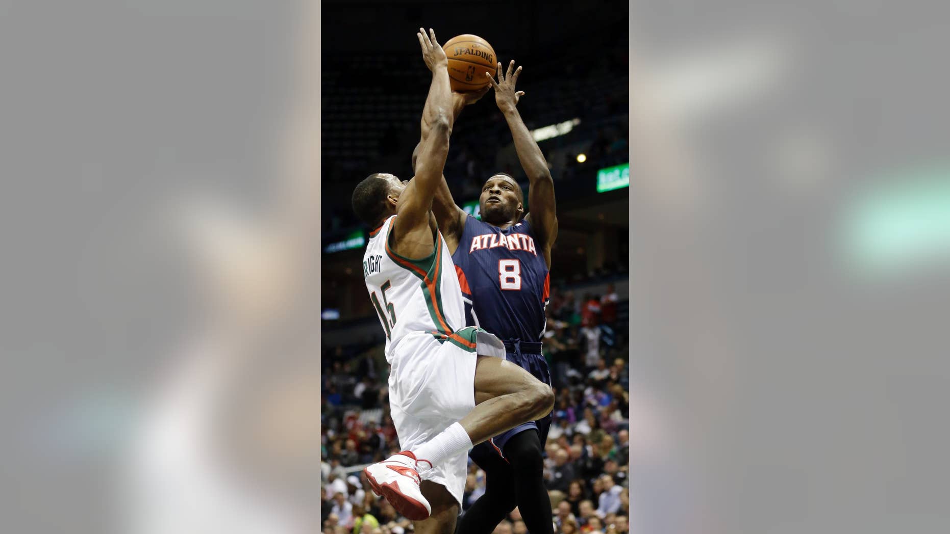 Atlanta Hawks' Shelvin Mack (8) shoots past Milwaukee Bucks' Chris Wright (15) during the first half of an NBA basketball game on Wednesday, April 16, 2014, in Milwaukee. (AP Photo/Morry Gash)