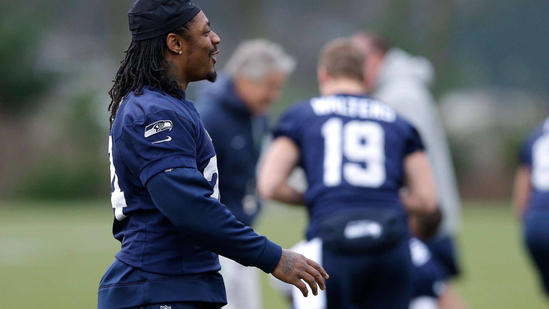 Seattle Seahawks NFL football running back Marshawn Lynch, left, walks during stretching warmups on Thursday, Jan. 2, 2014, before practice in Renton, Wash. (AP Photo/Ted S. Warren)