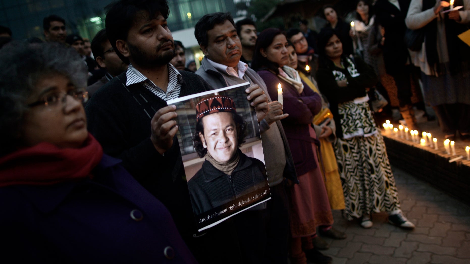 A Pakistani man holds a poster showing a victim of Thursday's deadly bombings in Quetta, while he and others attend a protest in Islamabad, Pakistan, Friday, Jan. 11, 2013. Shiites in a southwestern Pakistani city hit by a brutal terror attack refused to bury their dead Friday in protest, demanding that the government do something to protect them from what has become a barrage of bombings and shootings against the minority Muslim sect. Poster shows one of the (AP Photo/Muhammed Muheisen)