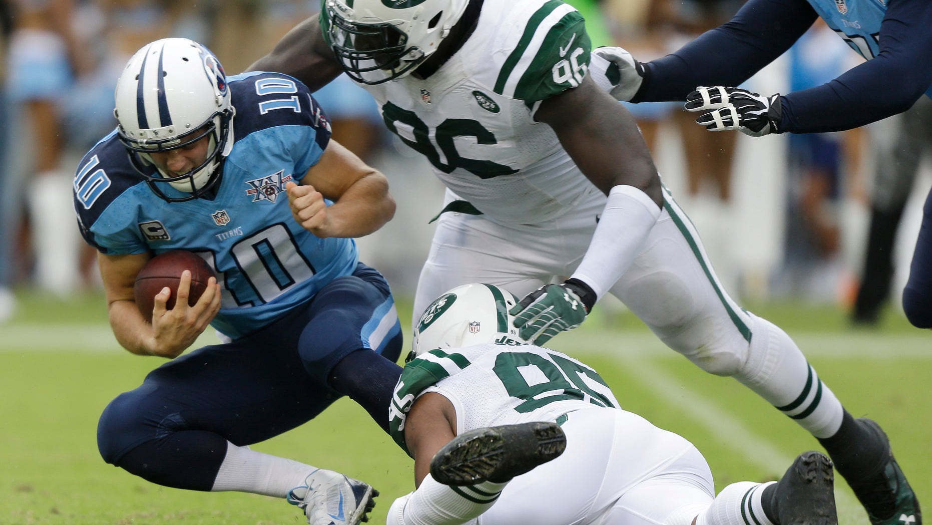 New York Jets defensive end Muhammad Wilkerson (96) and Antwan Barnes (95) bring down Tennessee Titans quarterback Jake Locker (10) in the second quarter of an NFL football game on Sunday, Sept. 29, 2013, in Nashville, Tenn. (AP Photo/Wade Payne)