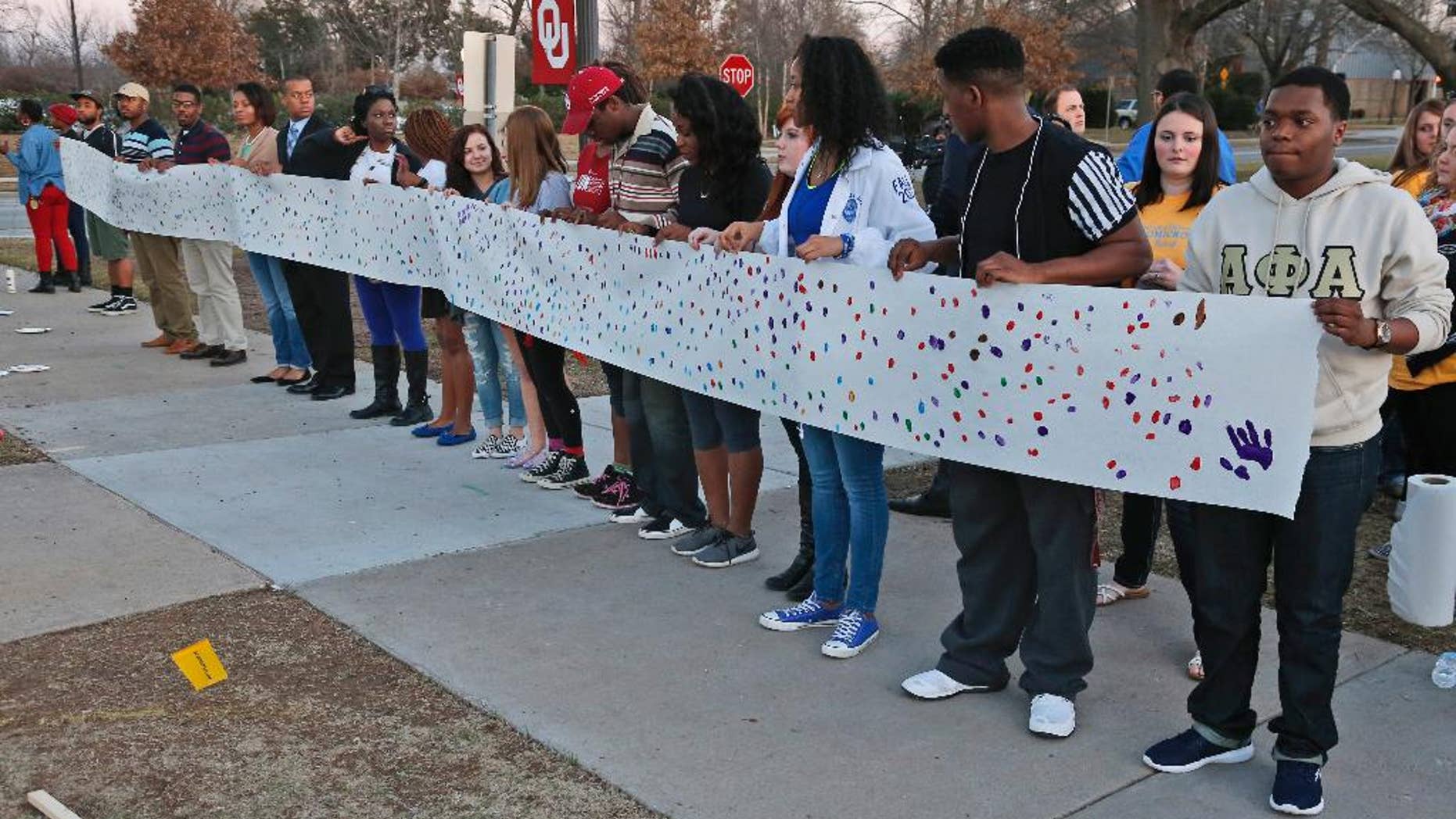 University of Oklahoma students hold a sign to be carried to the now closed University of Oklahoma's Sigma Alpha Epsilon fraternity house during a rally in Norman, Okla., Tuesday, March 10, 2015. The university's president expelled two students Tuesday after he said they were identified as leaders of a racist chant captured on video during a fraternity event. (AP Photo/Sue Ogrocki)
