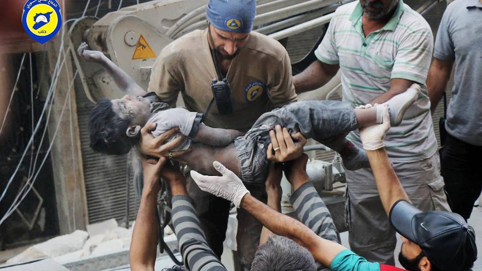 This Tuesday, Sept. 27, 2016 photo, provided by the Syrian Civil Defense group known as the White Helmets, shows a Civil Defense worker carrying the body of a child after airstrikes hit al-Shaar neighborhood in Aleppo, Syria. Pope Francis has decried the assault on the Syrian city of Aleppo, saying those responsible for the bombing must answer to God. (Syrian Civil Defense White Helmets via AP)