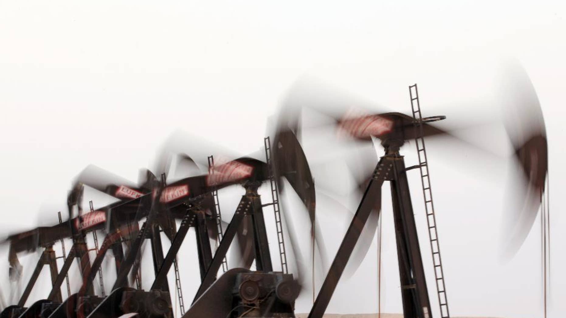 A row of oil pumps work in the desert oil fields of Sakhir, Bahrain. OPEC nations have agreed to keep supply steady, putting new pressure on US producers.