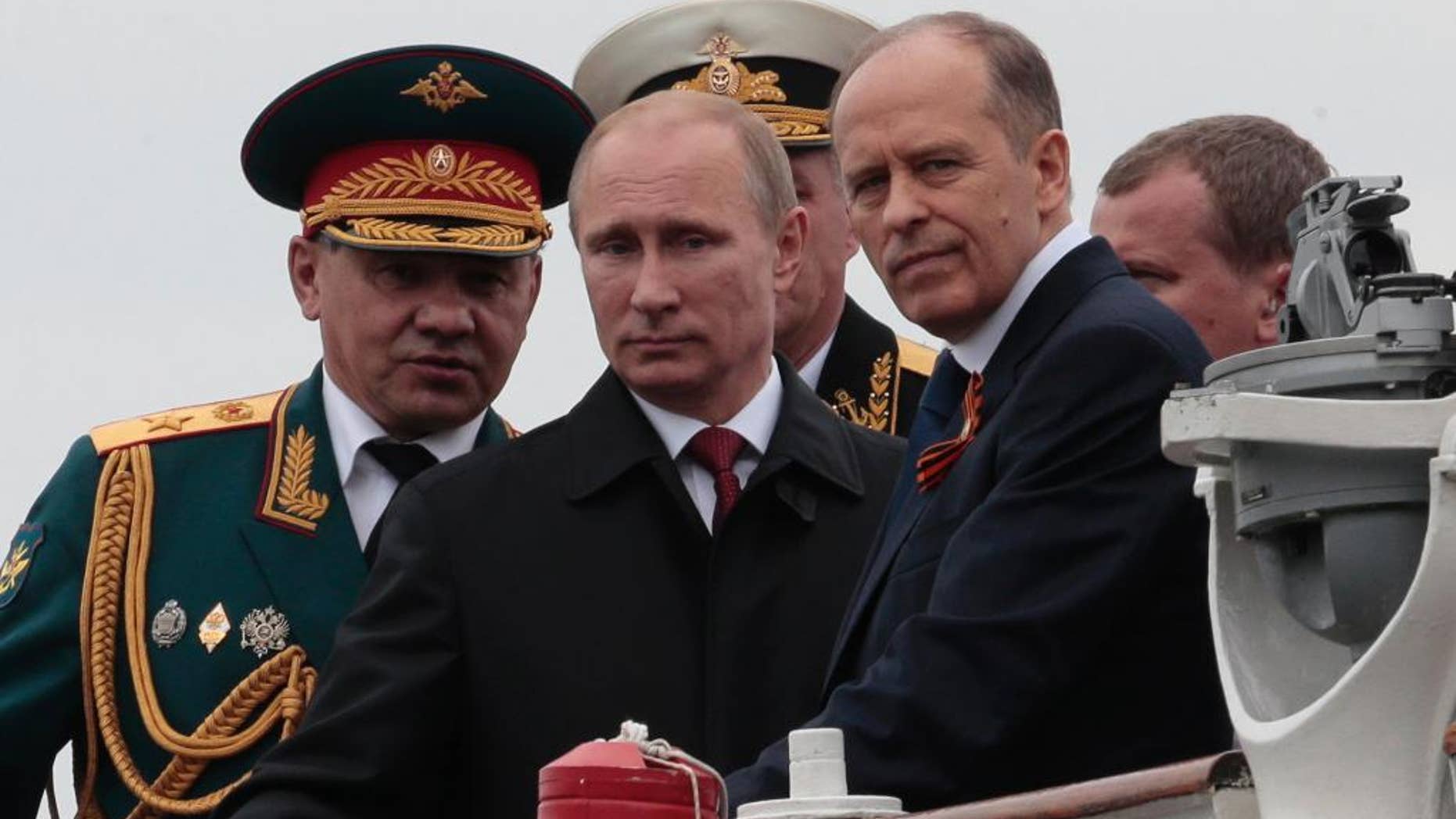 FILE - In this file photo taken on Friday, May 9, 2014, Russian President Vladimir Putin, centre, flanked by Defense Minister Sergei Shoigu, left, and Federal Security Service Chief Alexander Bortnikov, right, arrives on a boat after inspecting battleships during a navy parade marking the Victory Day in Sevastopol, Crimea. Putin on Thursday Aug. 11, 2016, directly accused the Ukrainian government of plotting attacks in the Crimea, and called for increased security in the Russian annexed Black Sea peninsula. (AP Photo/Ivan Sekretarev, FILE)