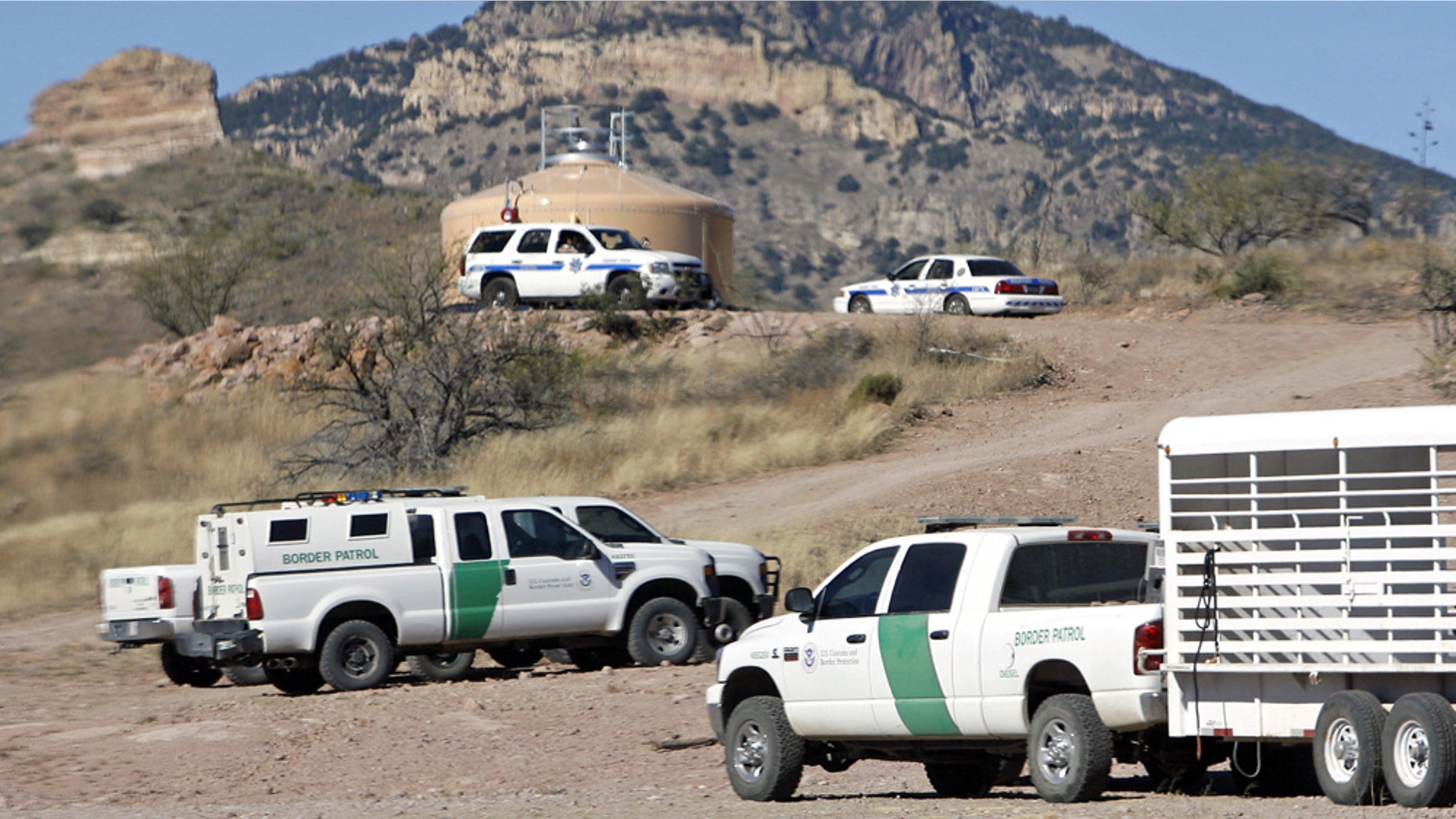 U.S. Border Patrol and Arizona Department of Public Safety vehicles crowd an area near Pena Blanca Lake in Coronado National Forest northwest of Nogales, Ariz., on Wednesday, Dec. 15, 2010, during a search for a suspect in an overnight shootout resulted in the death of a Border Patrol agent. (AP Photo/Arizona Daily Star, Greg Bryan)