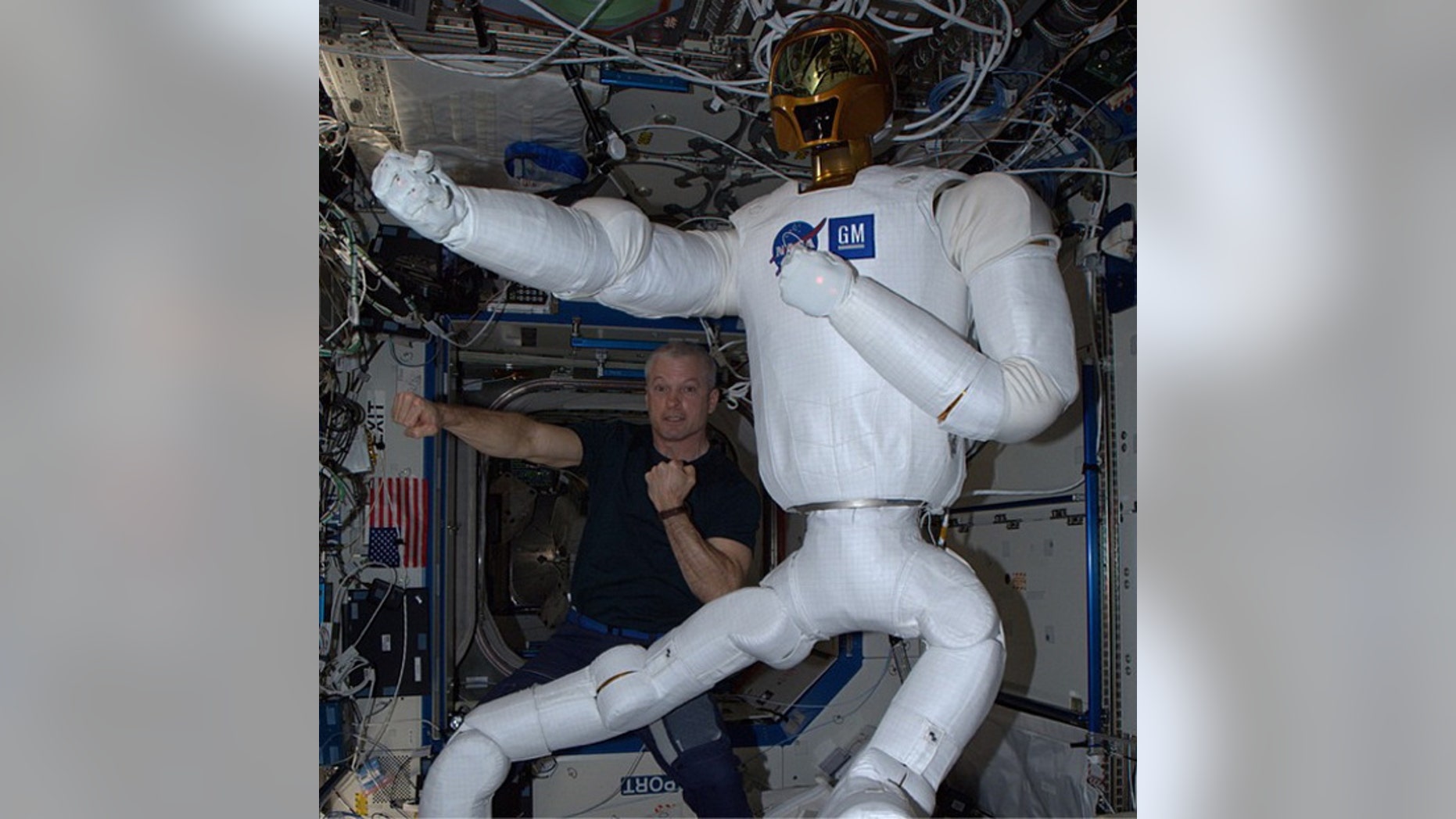 NASA astronaut Steve Swanson poses with the robot Robonaut 2 on the International Space Station after completing an upgrade that gave the robot legs.