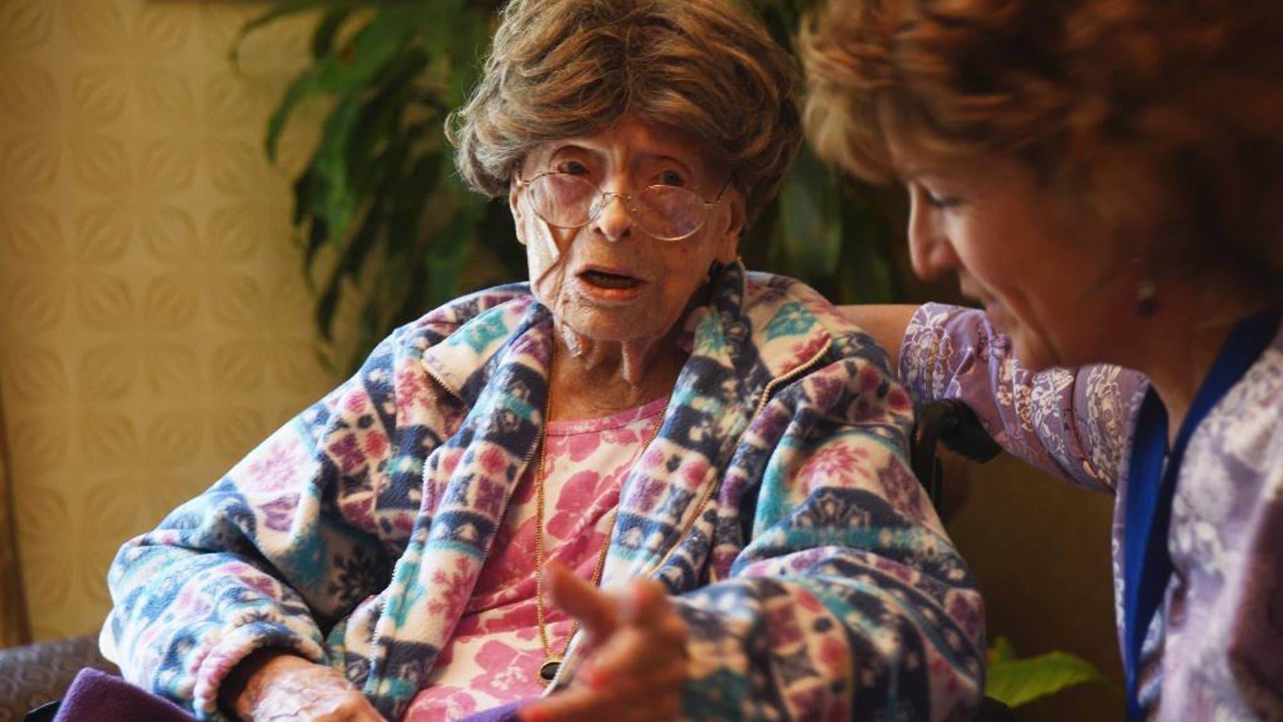 FILE - In this July 19, 2016, file photo, Adele Dunlap, 113, talks with Susan Dempster, the Activities Director at Country Arch Care Center in Pittstown, N.J. Dunlap received balloons and fellow residents at the Country Arch Care Center in Pittstown on Monday, Dec. 12, sang “Happy Birthday” to the now 114-year-old. Dunlap became the country's oldest person in July. (Chris Pedota/The Record via AP, File)