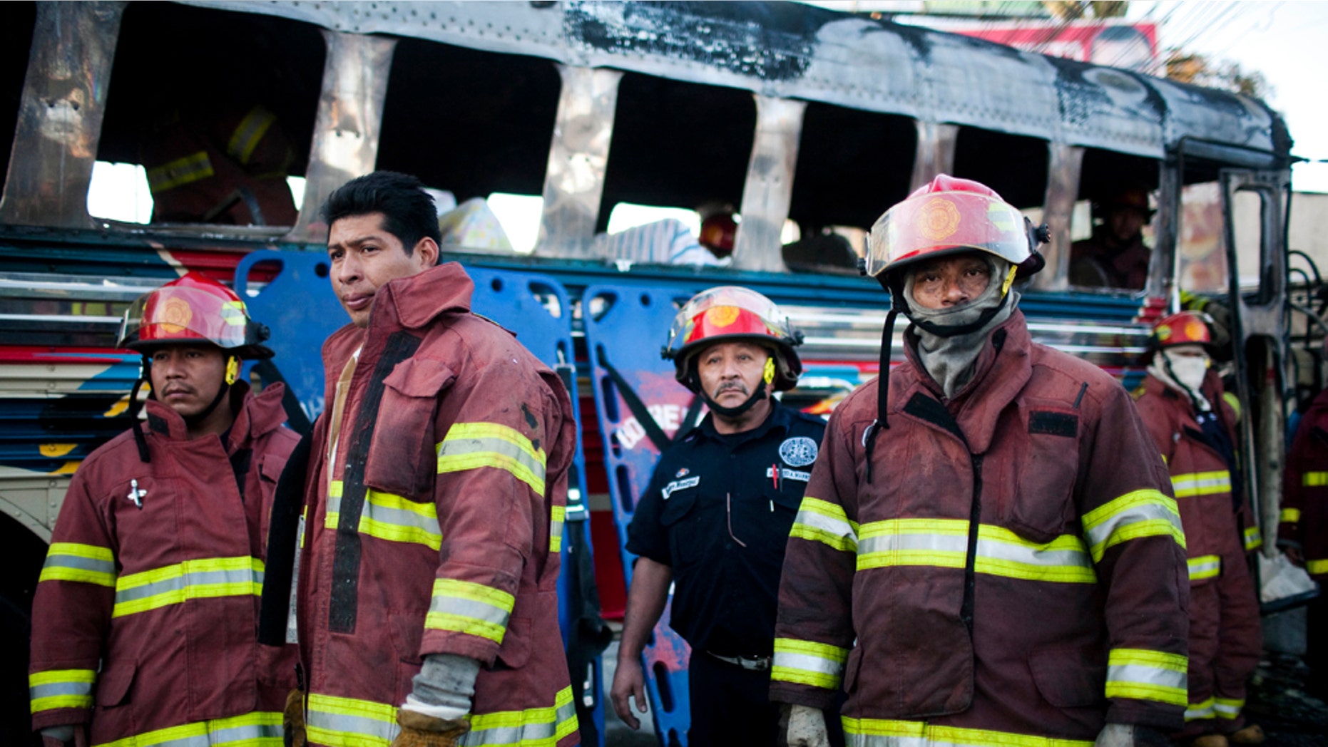 Firefighters rest after extinguishing a fire inside a bus caused by an explosion where five people died and 16 were injured in Guatemala City, Monday Jan. 3, 2011. The cause of the explosion is unknown. (AP Photo/Rodrigo Abd)