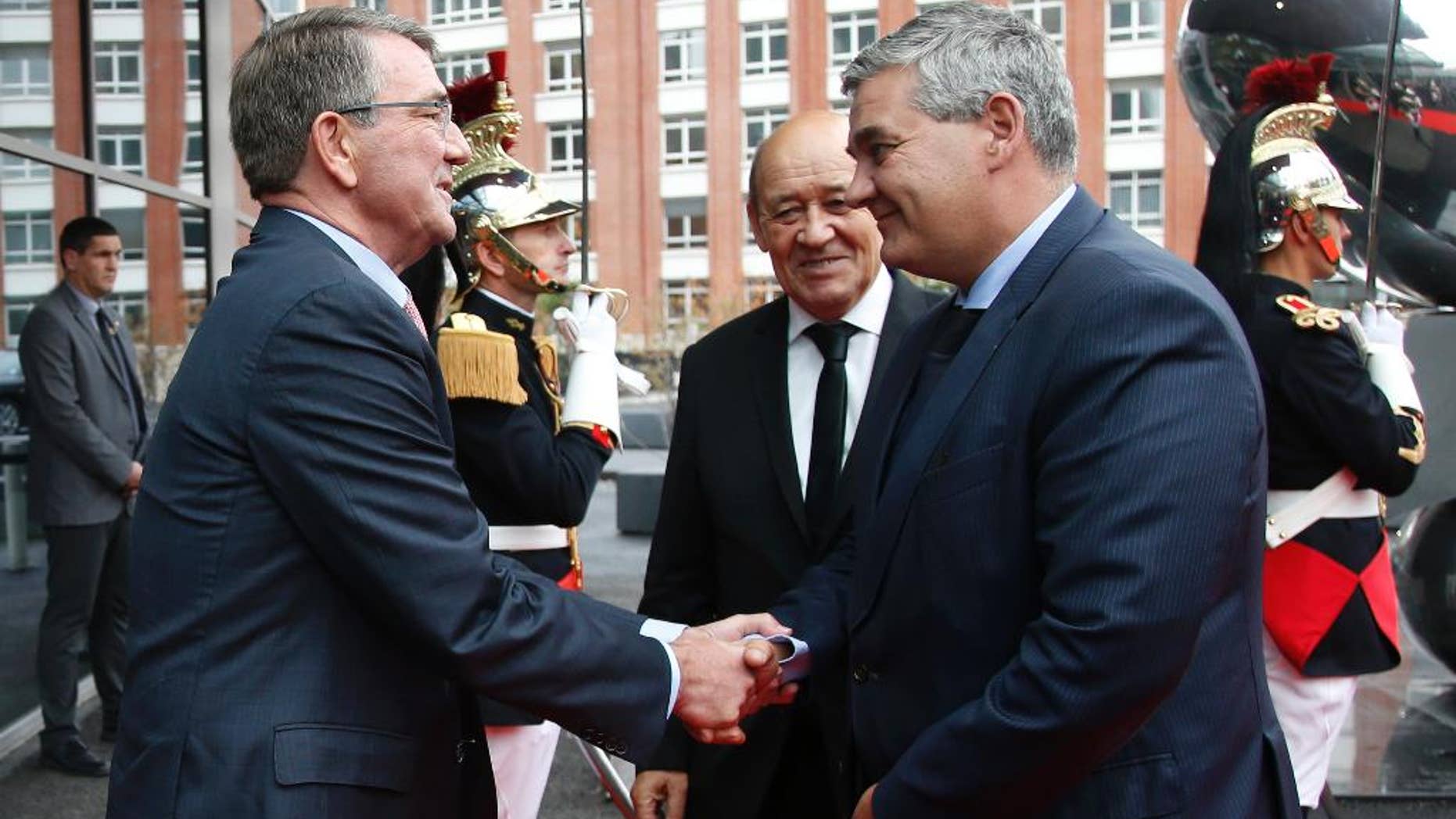 U.S. Defense Secretary Ash Carter, left, and French Defense Minister Jean-Yves Le Drian, center, greet Belgian Defense Minister Steven Vandeput, right, upon arrivals for a meeting by dozen members of the US-led coalition fighting Islamic State in Iraq and Syria in Paris, Tuesday, Oct. 25, 2016. France's president calls on the U.S. and other allies fighting Islamic State extremists in Iraq to remain vigilant and share intelligence to prevent potential reprisals from the group. (Charles Platiau/Pool Photo via AP)
