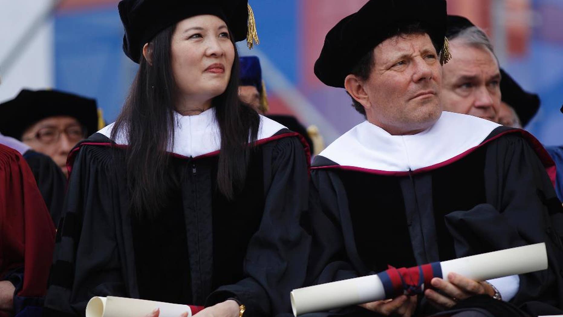 FILE - In this May 16, 2011 photo, Pulitzer Prize Winners Sheryl WuDunn and her husband New York Times columnist Nicholas Kristof, are seen after receiving honorary degrees at the University of Pennsylvania's 255th Commencement in Philadelphia. Kristof said in a message on Twitter that there had been “big excitement” when he “interrupted an intruder” in his room early Saturday, Nov. 12, 2016 at the Franklin Hotel near Independence Hall and the Liberty Bell. A police spokesman confirmed the account, saying the columnist “chased him, struggled with him and held him until officers arrived.” (AP Photo/Matt Rourke)