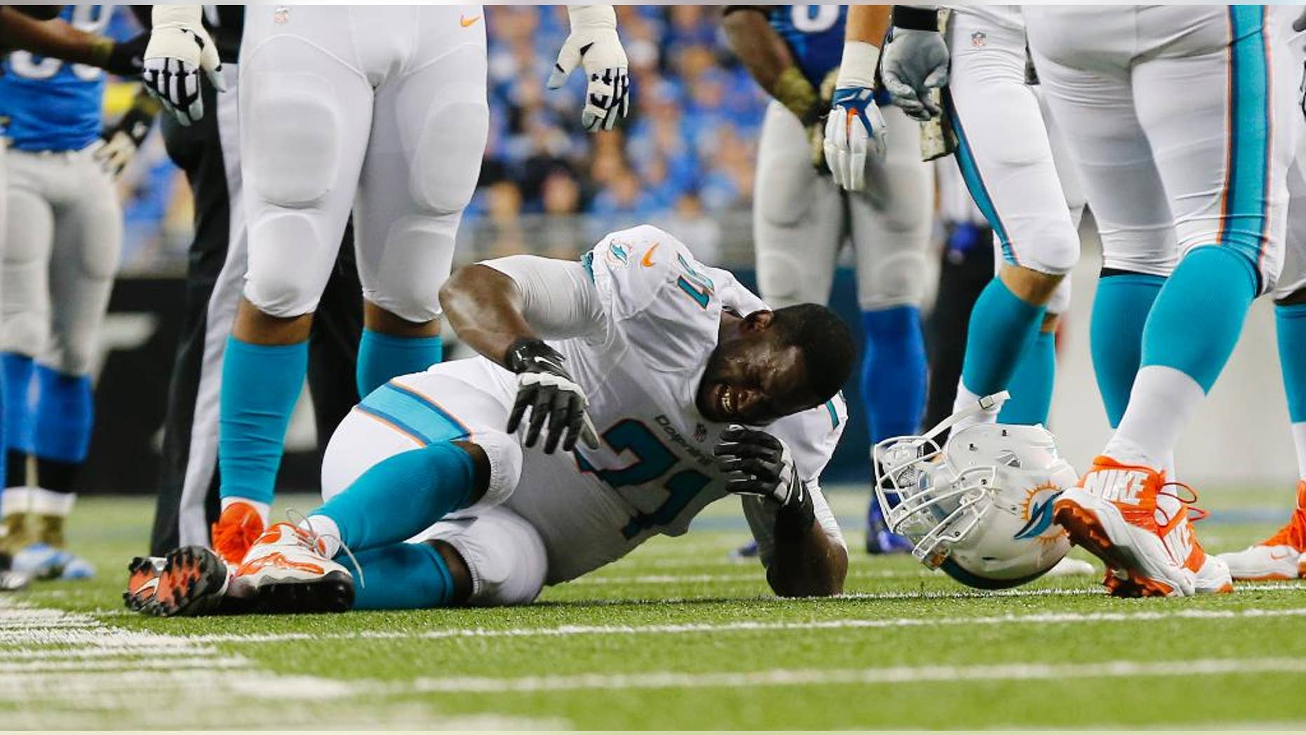 Miami Dolphins tackle Branden Albert (71) grimaces during the first half of an NFL football game against the Detroit Lions in Detroit, Sunday, Nov. 9, 2014. Albert was carted off the field. (AP Photo/Paul Sancya)