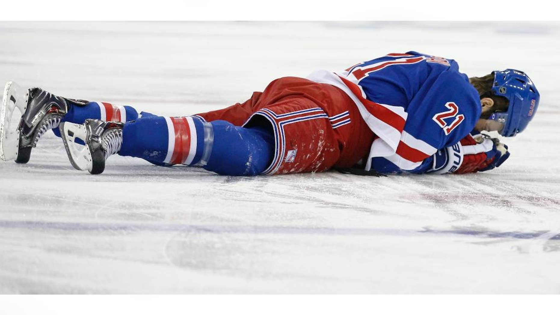 In this May 22, 2014 file photo, New York Rangers center Derek Stepan (21) lies on the ice after taking a hit from Montreal Canadiens forward Brandon Prust during the first period of Game 3 of the NHL hockey Stanley Cup playoffs Eastern Conference finals in New York. Stepan has a broken jaw and is undergoing surgery. Rangers coach Alain Vigneault made the surprising announcement Friday, May 23, 2014, on the first of two off days in the series New York leads 2-1. Prust wasn't penalized in the first period of Montreal's 3-2 overtime win Thursday night, but he faces an NHL hearing Friday and a possible suspension. (AP Photo/Kathy Willens)