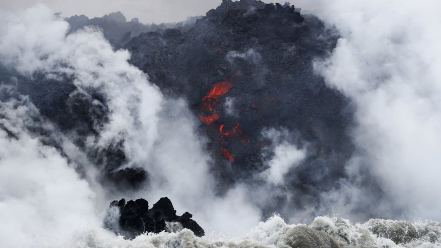 FILE: Lava flows into the ocean near Pahoa, Hawaii. Officials say an explosion sent lava flying through the roof of a tour boat.