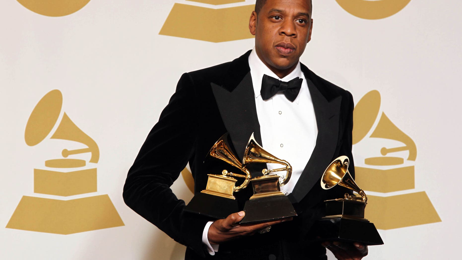 Jay-Z poses backstage with the awards for best rap/sung collaboration for "No Church in the Wild" and best rap performance for "N****s in Paris" at the 55th annual Grammy Awards on Sunday, Feb. 10, 2013, in Los Angeles.
