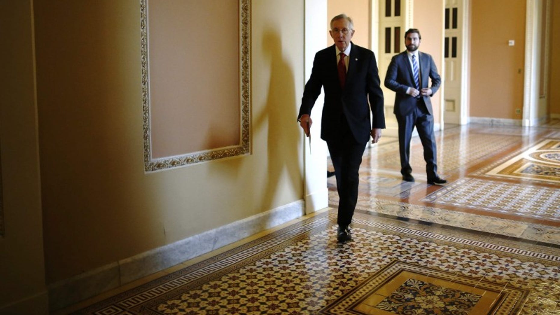 Senate Majority Leader Harry Reid walks to address reporters after the weekly Republican caucus luncheon at the U.S. Capitol in Washington March 11, 2014. (REUTERS/Jonathan Ernst)