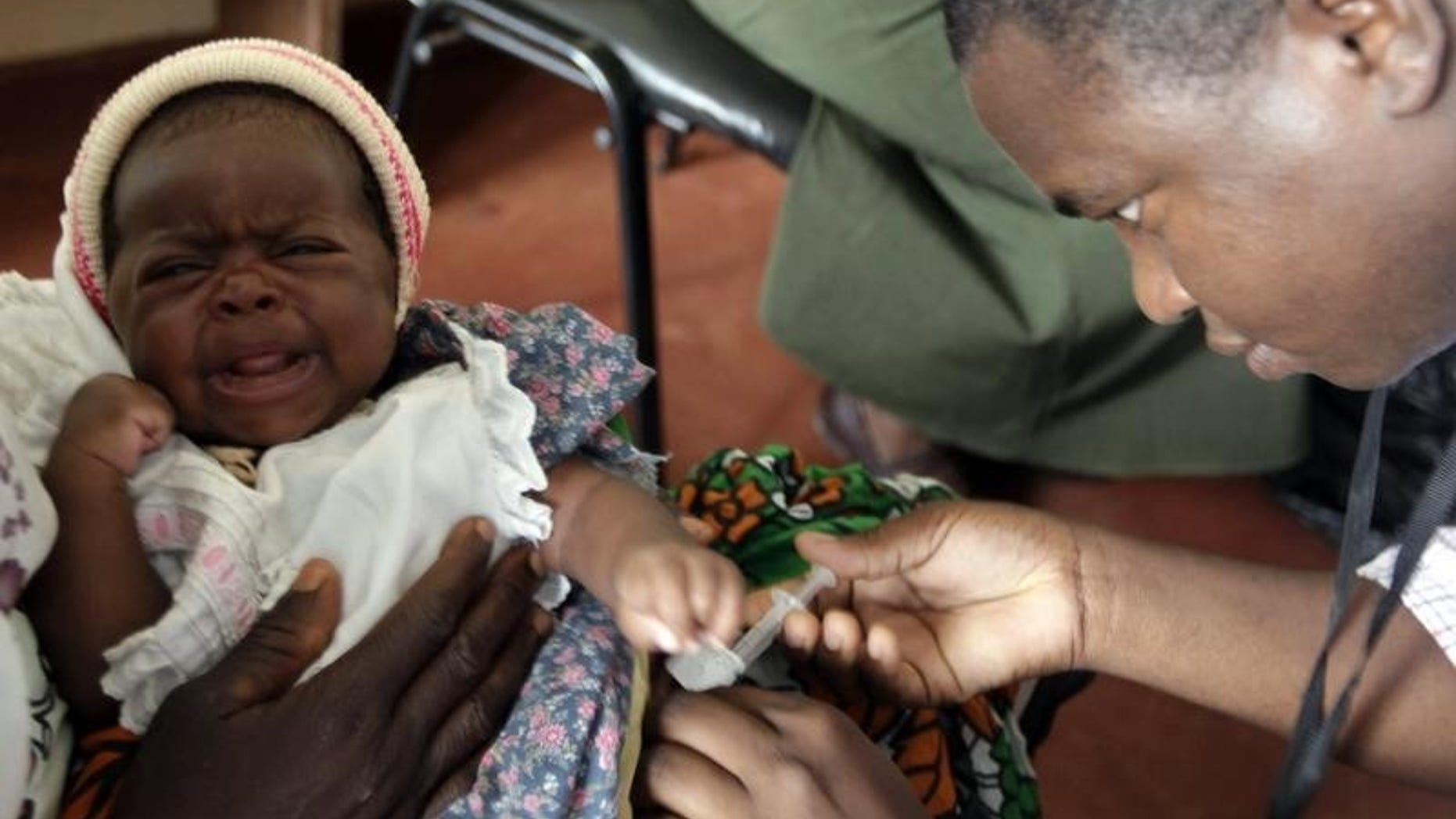 A child is given an injection as part of a malaria vaccine trial at a clinic in the Kenya coastal town of Kilifi, November 23, 2010. REUTERS/Joseph Okanga